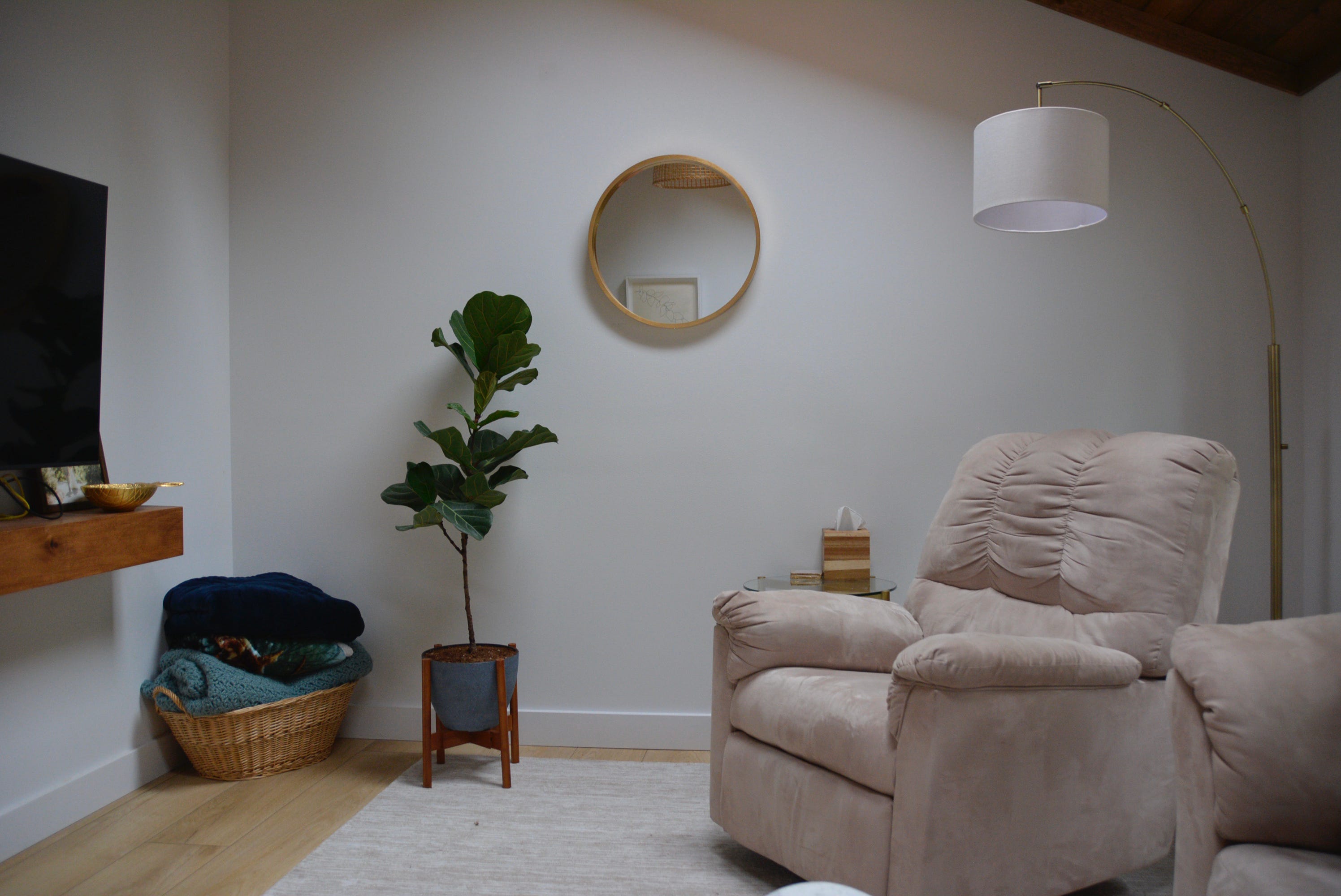 Kleiner runder Spiegel und Pflanze vor weißer Wand