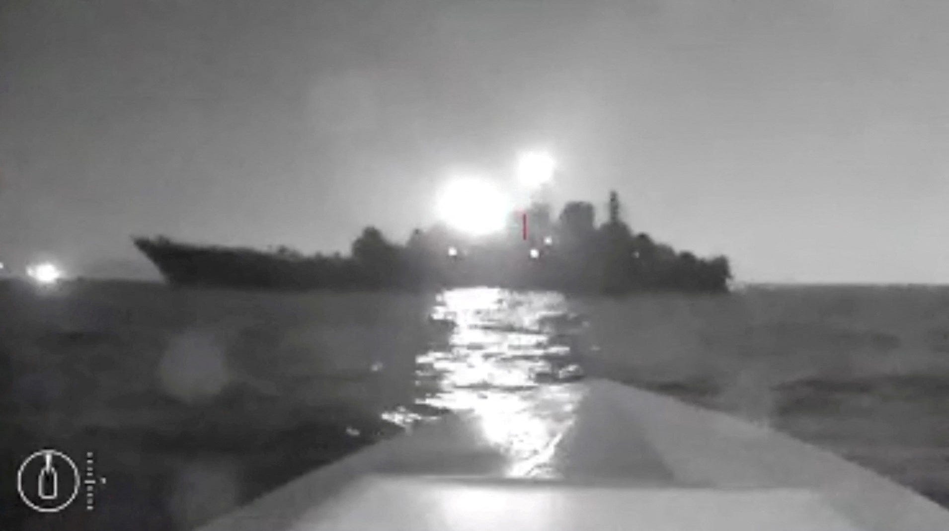 Ein verschwommener Schwarz-Weiß-Screenshot aus Drohnenaufnahmen, der die Silhouette eines Schiffes zeigt.