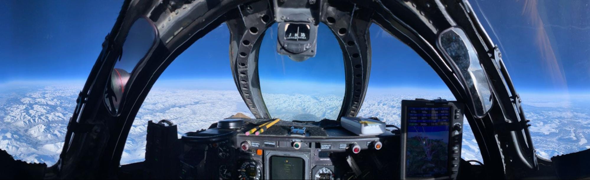 Ein Bild aus dem Inneren eines Cockpits zeigt den Himmel und die Wolken darunter