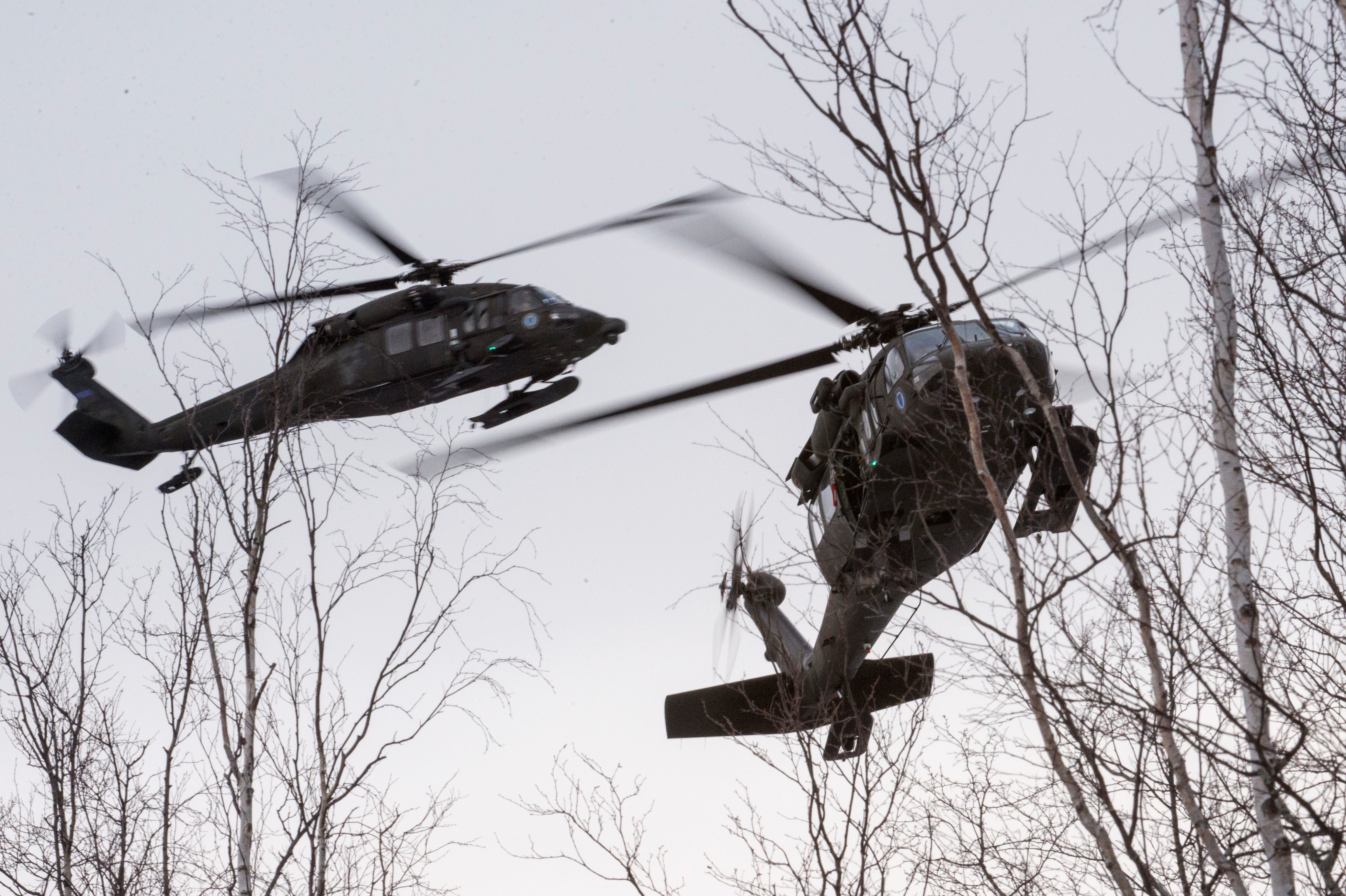 Zwei UH-60 Black Hawk-Hubschrauber der Alaska Army National Guard des 1. Bataillons des 207. Luftfahrtregiments nähern sich einem Scheinevakuierungsort, während sie am 21. November 2017 an einer Schulung zur Massenunfallopferung auf dem Joint Base Elmendorf-Richardson, Alaska, teilnehmen.