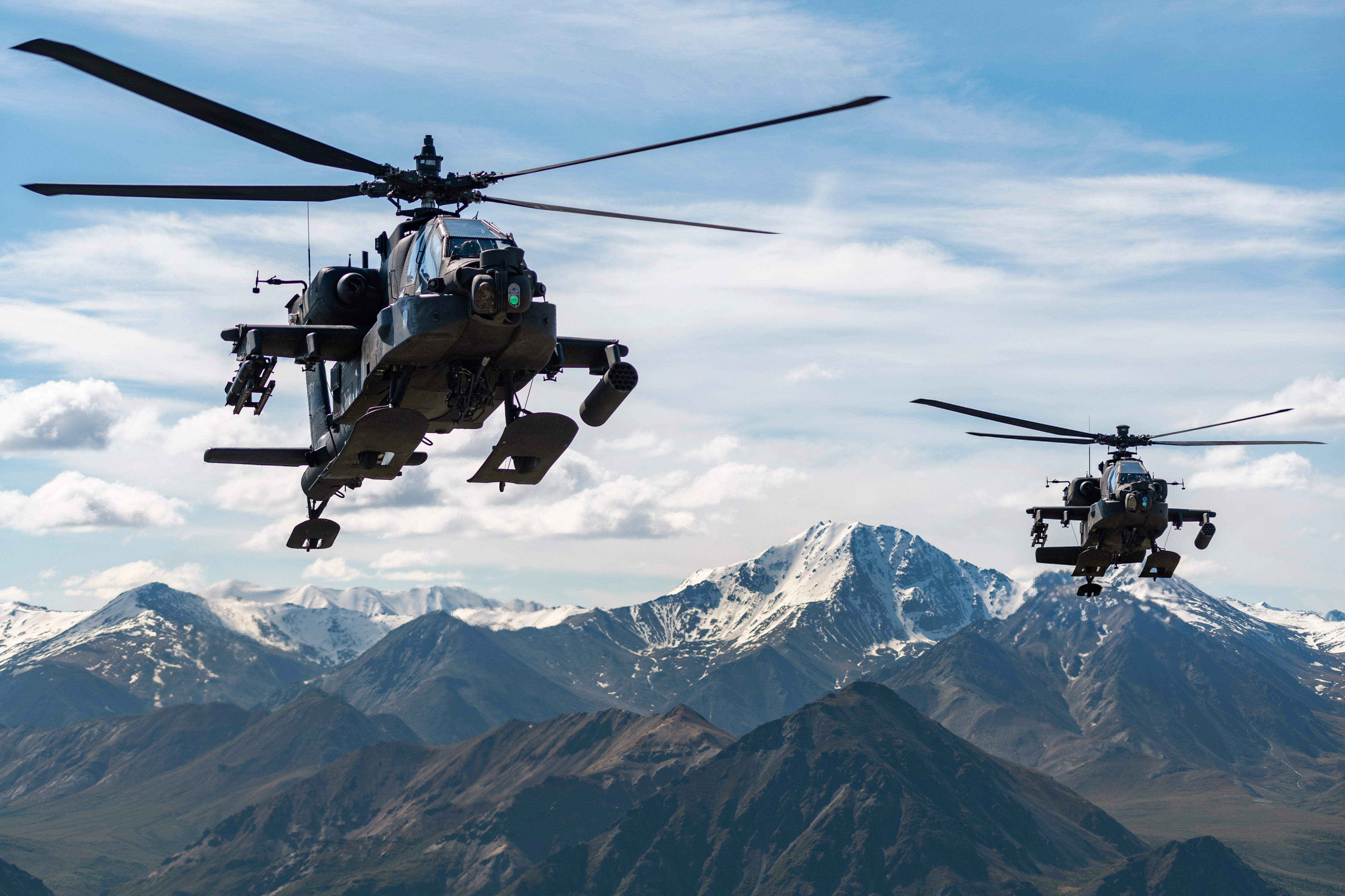 AH-64D Apache Longbow-Kampfhubschrauber fliegen am 3. Juni 2019 über eine Bergkette in der Nähe von Fort Wainwright, Alaska.