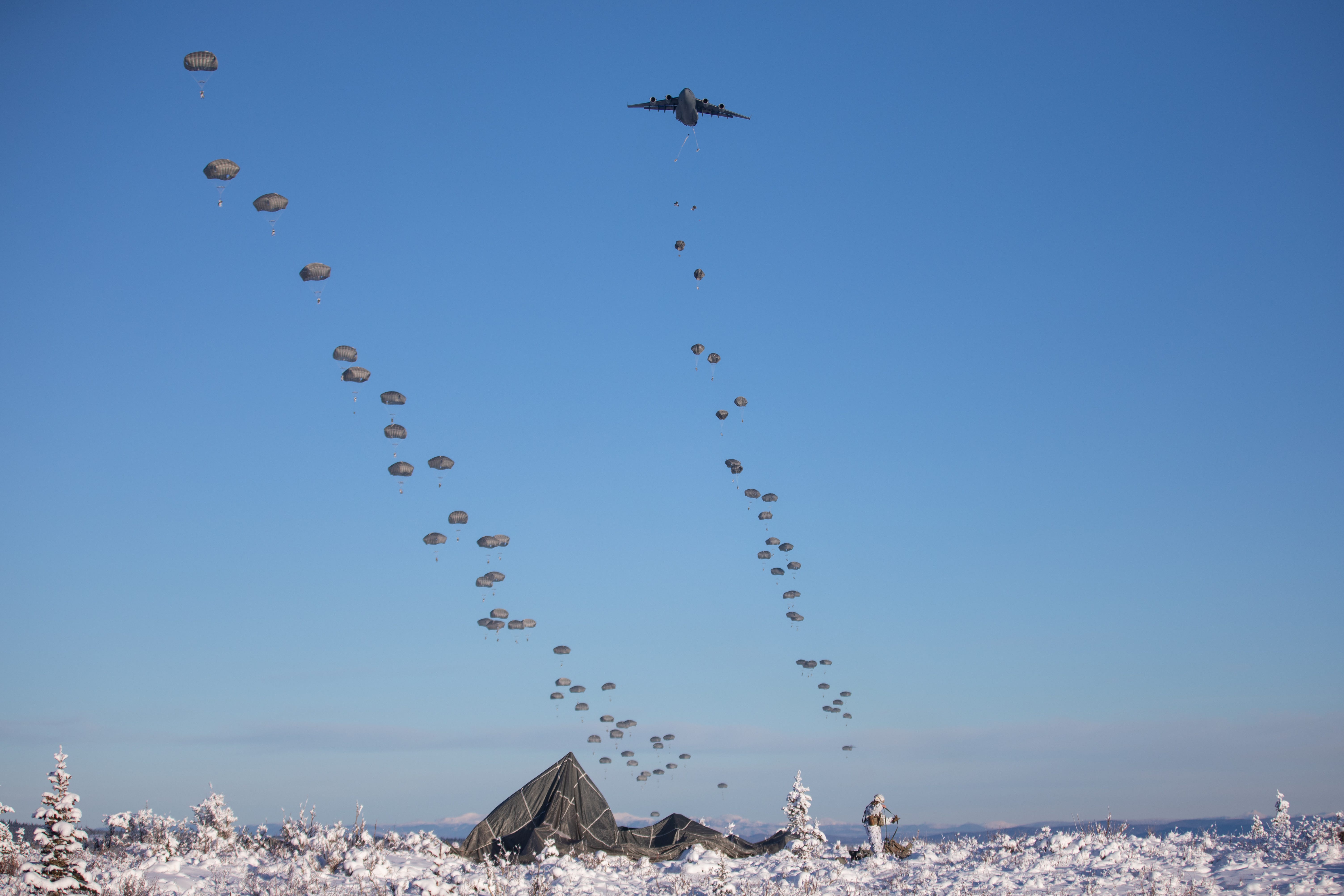 Fallschirmjäger der US-Armee, die dem 3. Bataillon, dem 509. Fallschirmjägerregiment, dem 2. Infanteriebrigade Combat Team (Airborne) und der 11. Luftlandedivision zugeteilt sind, steigen während eines Lufteinsatzes im Rahmen des Joint Pacific Multinational Readiness Center 24 von C-17 Globemaster IIIs in die Donnelly Drop Zone ab -02 auf dem Donnelly Training Area, Alaska, 8. Februar 2024.
