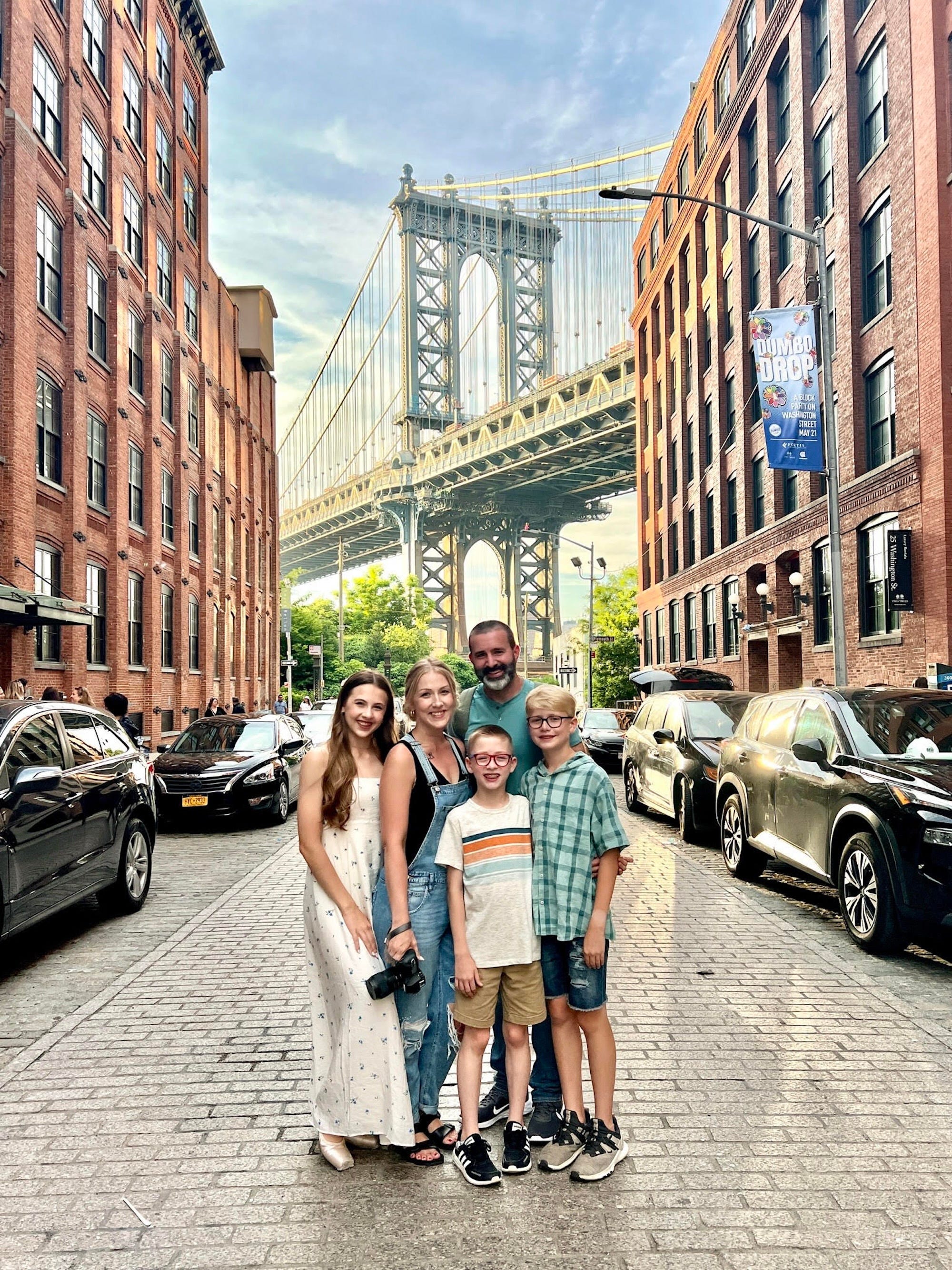 Eine fünfköpfige Familie steht vor der Brooklyn Bridge.