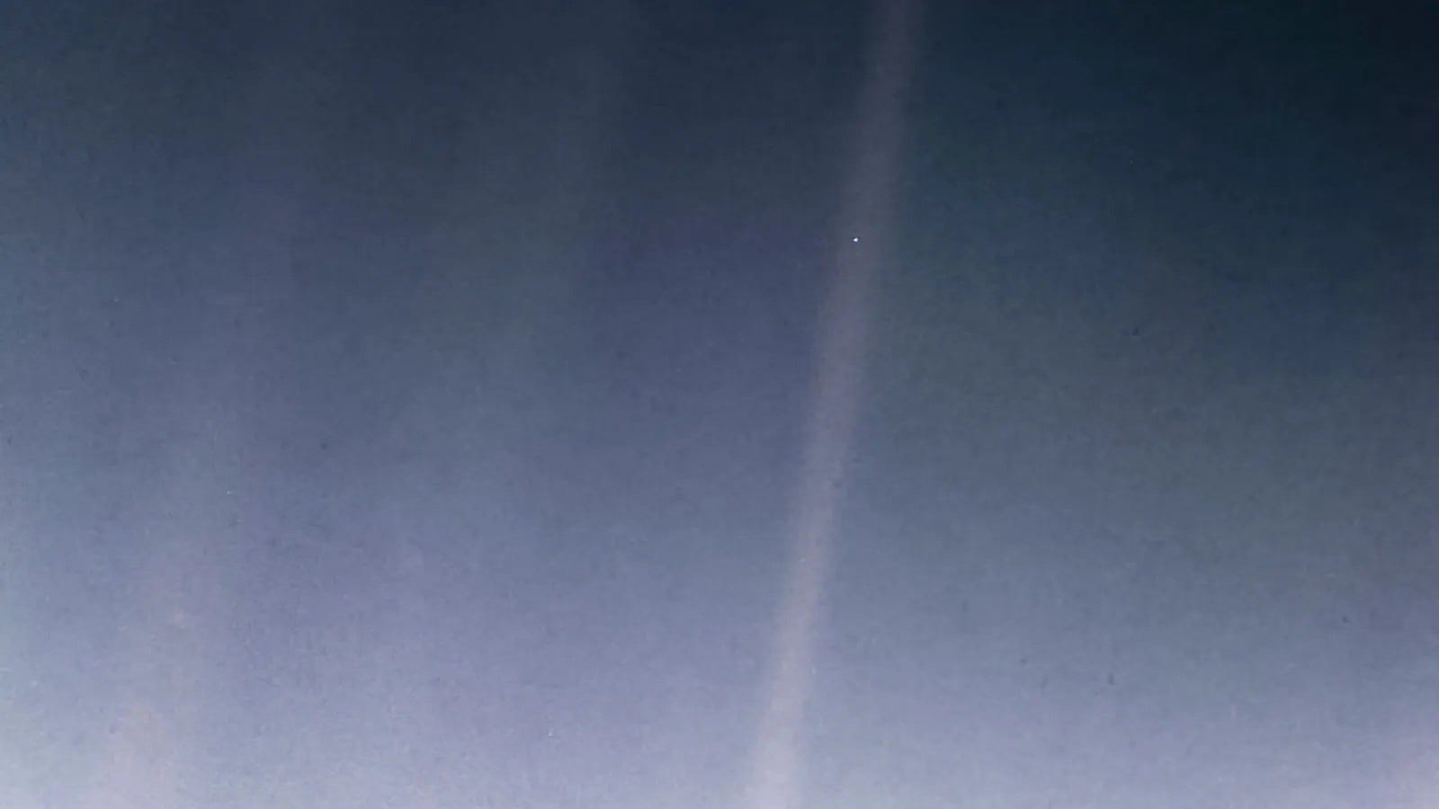 Foto der Erde als blassblauer Punkt, aufgenommen aus Milliarden Kilometern Entfernung im Weltraum