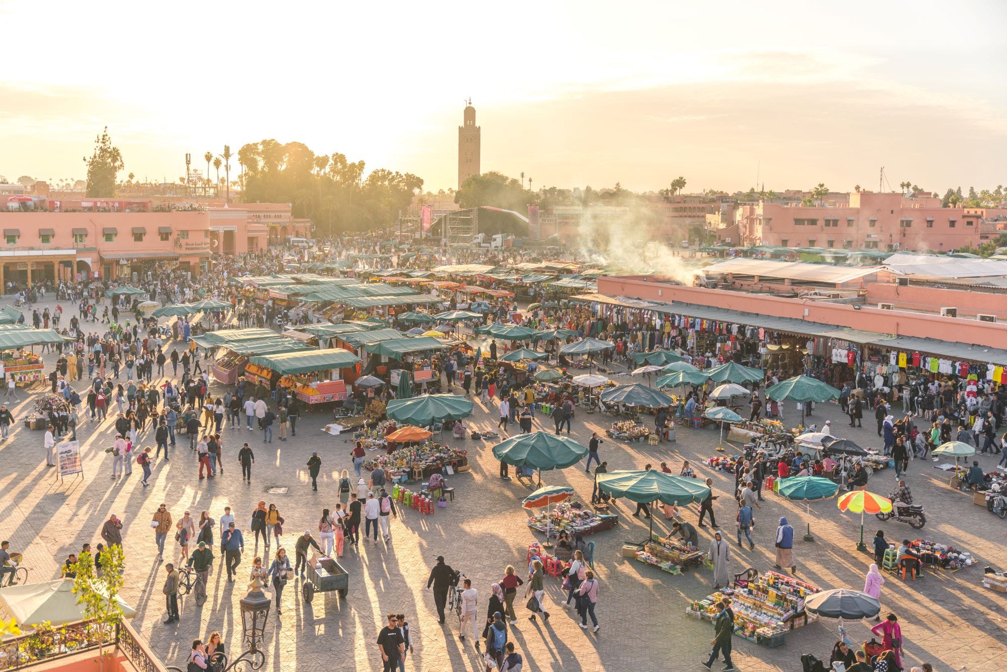 Platz Djemaa el Fna voller Menschenmassen bei Sonnenuntergang, Marrakesch, Marokko