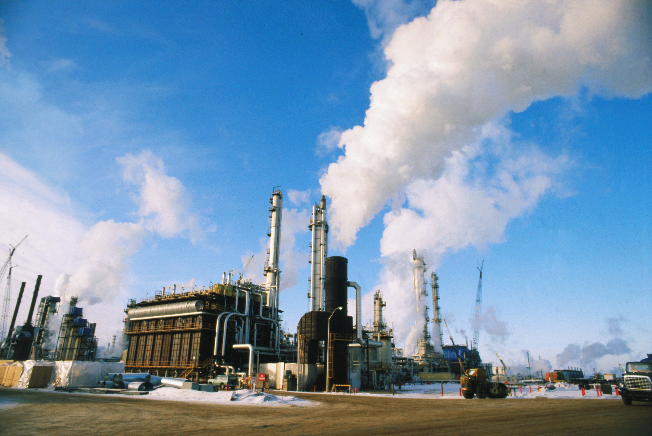 Wasserstoffkraftwerk mit hohen Schornsteinen, die Dampfwolken in einen blauen Himmel ausstoßen
