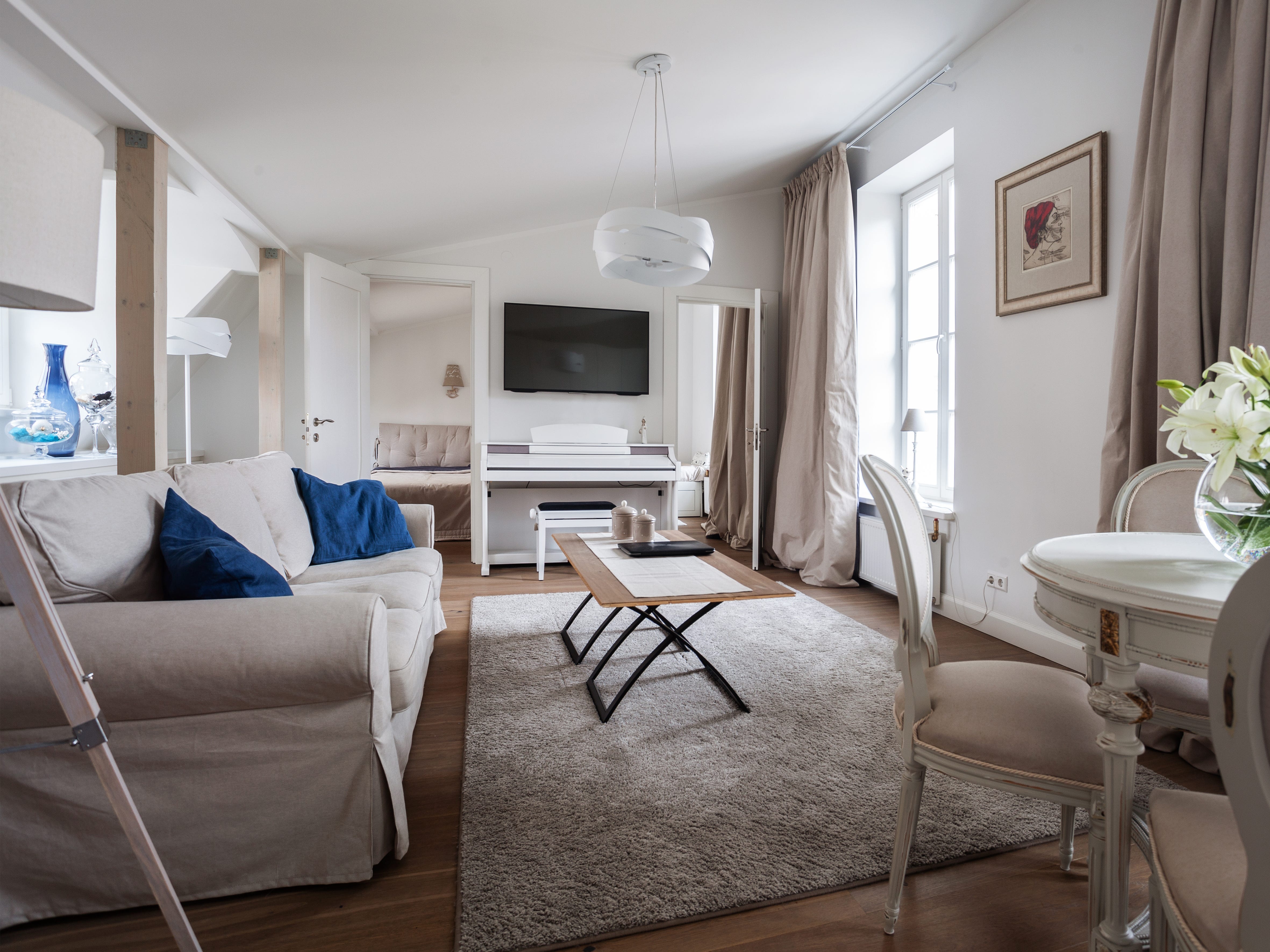 Wohnzimmer mit weißem Shabby-Chic-Sofa, Couchtisch und Fernseher