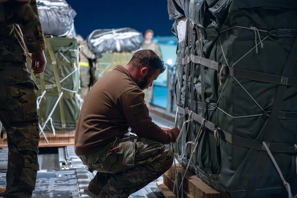 Flieger der US-Luftwaffe und Soldaten der US-Armee bereiten Pakete humanitärer Hilfe für den Abwurf an Bord einer C-130J Super Hercules vor.