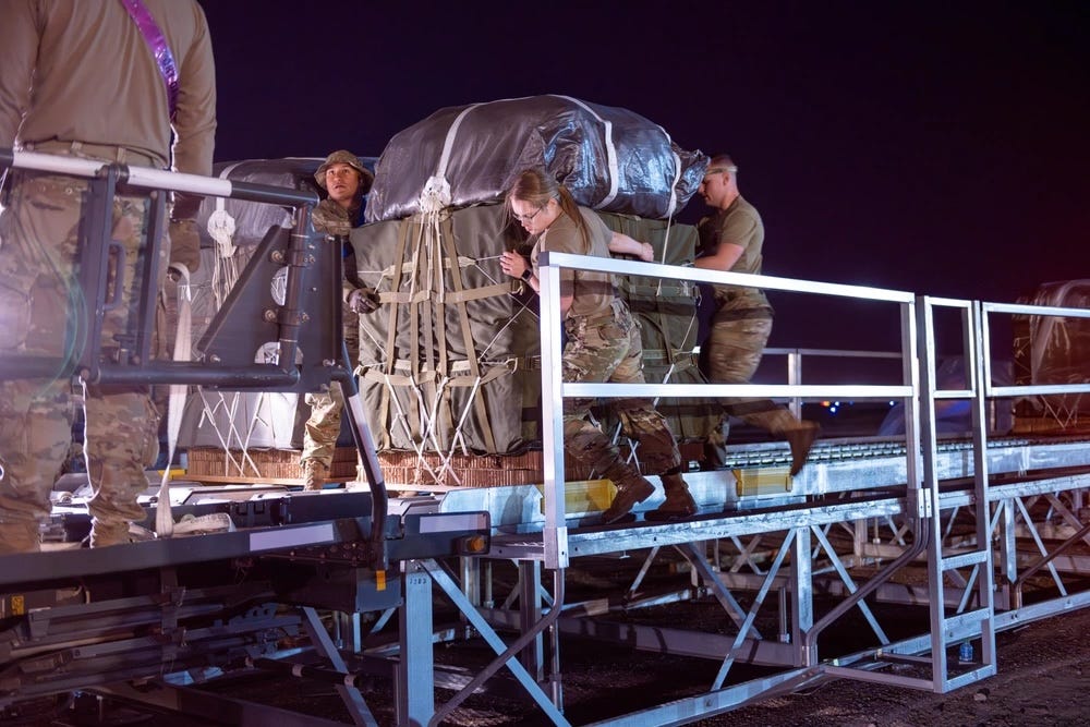 Lufthafenflieger der US-Luftwaffe und Fallschirmspringer der US-Armee bringen Paletten mit humanitärer Hilfe für Gaza auf einen K-Loader.