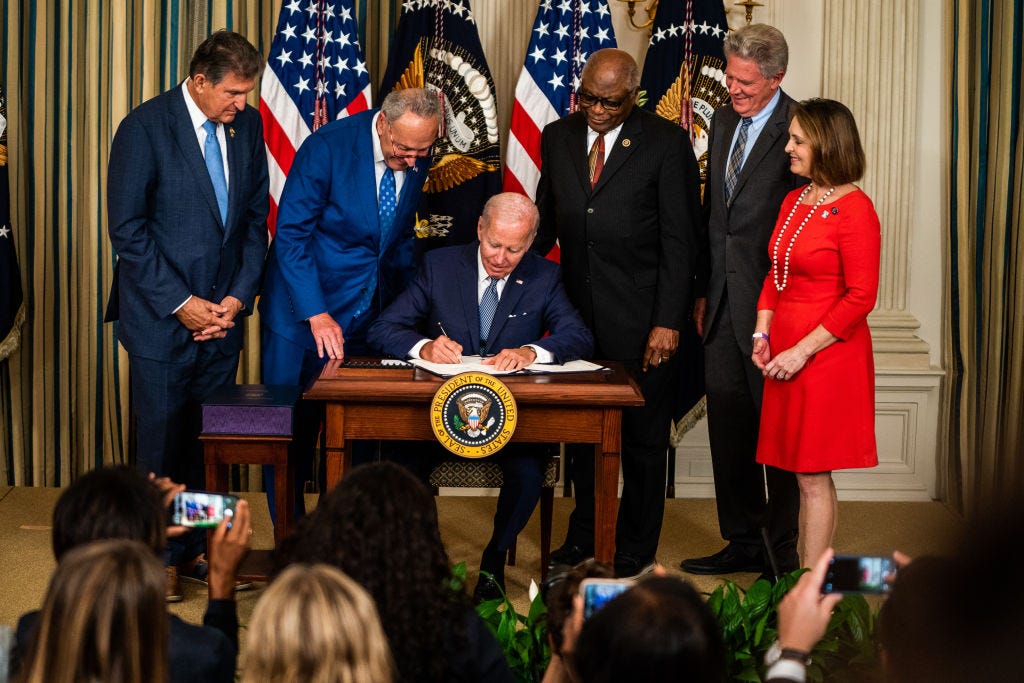 Präsident Joe Biden unterzeichnet im Weißen Haus im Kreise von Kongressabgeordneten das Inflation Reduction Act.