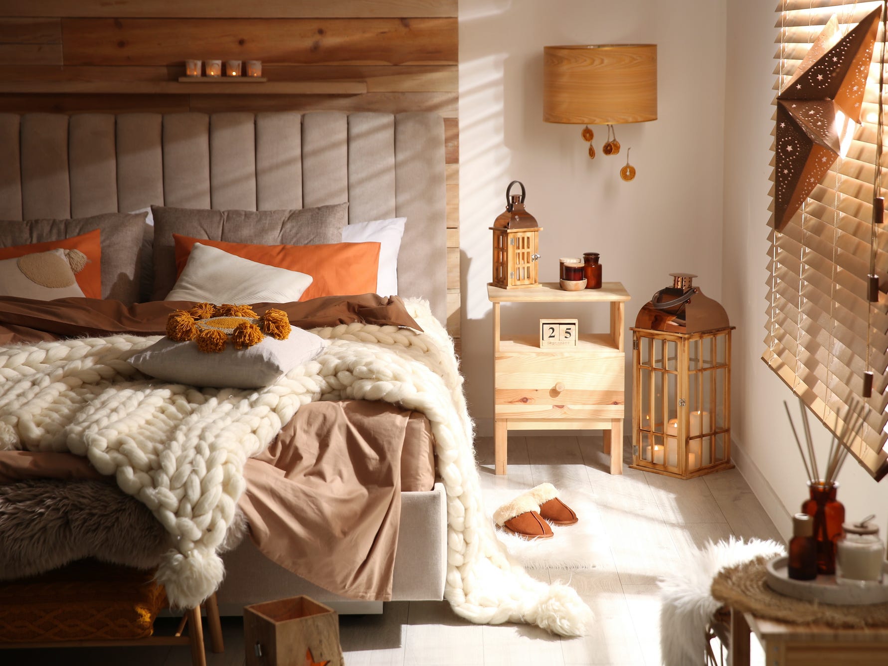 Gemütliches Boho-Schlafzimmer mit hellem Holz und orangefarbenen Dekordetails