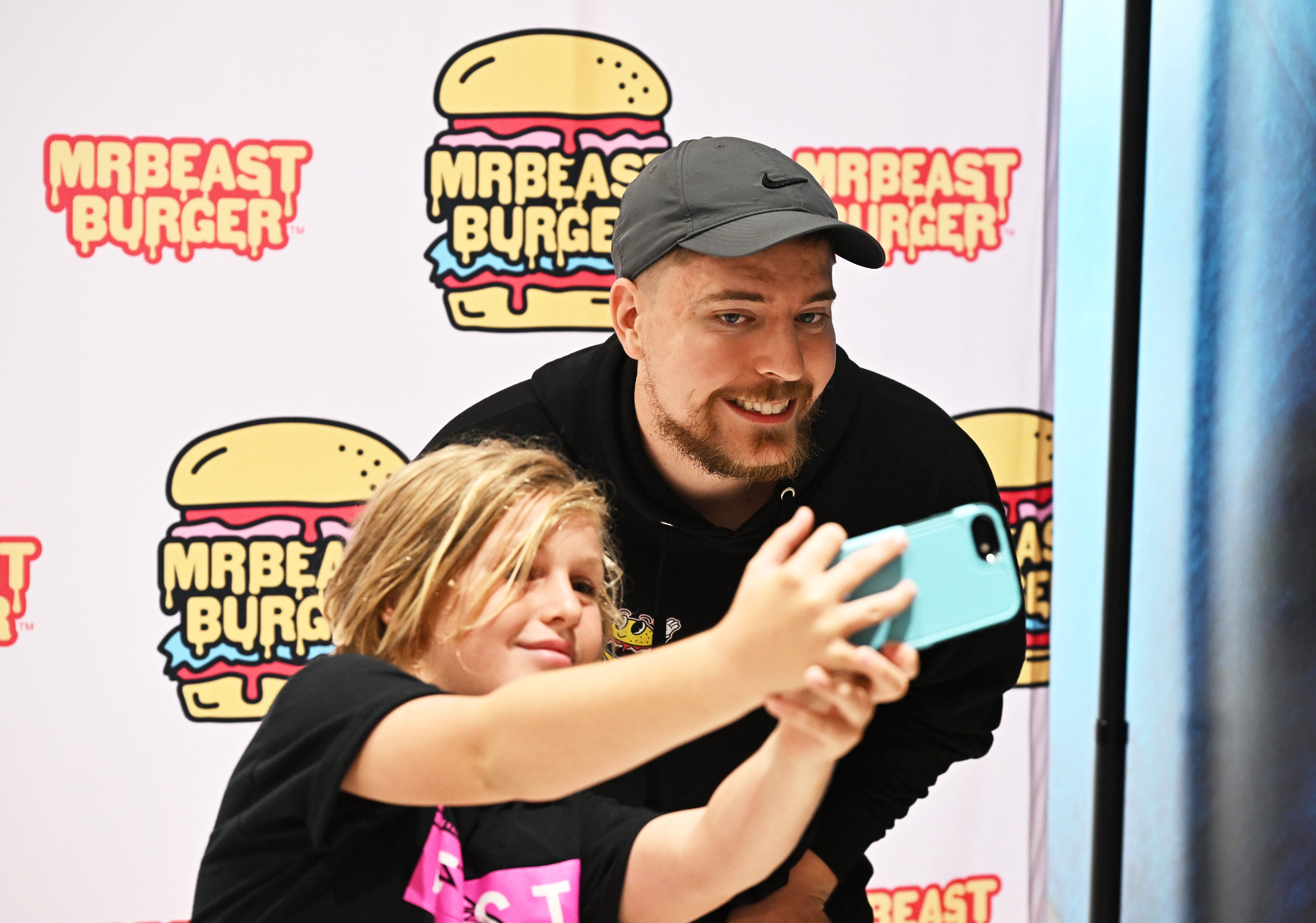 MrBeast macht ein Selfie mit einem Fan bei einer MrBeast-Burger-Veranstaltung.