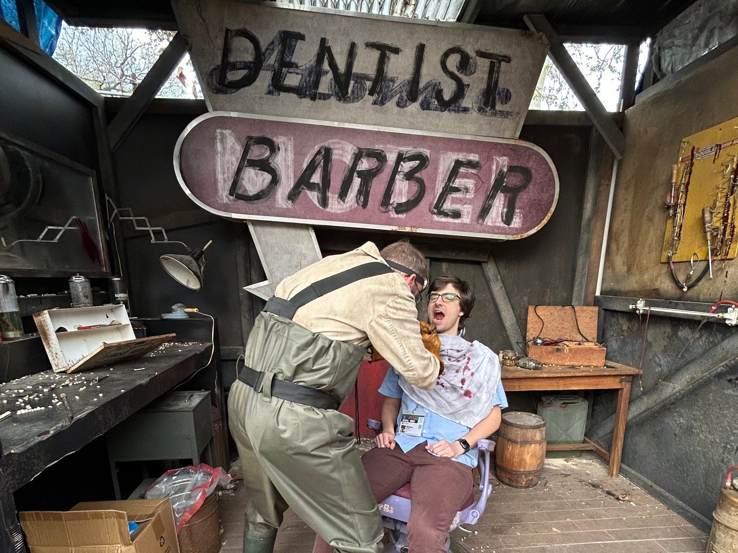 Zahnarzt-Friseur zieht Zähne eines sitzenden Mannes während der interaktiven Amazon-Ausstellung
