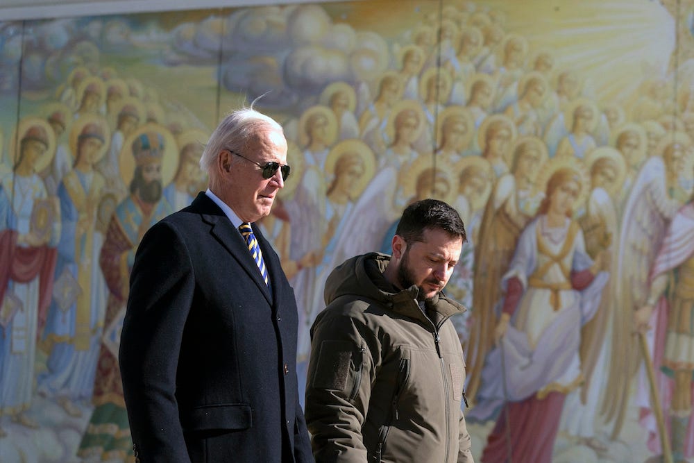 US-Präsident Joe Biden (links) geht mit dem ukrainischen Präsidenten Wolodymyr Selenskyj während eines unangekündigten Besuchs in Kiew, Ukraine, am Montag, den 20. Februar 2023, vor einem farbenfrohen Engelsgemälde in der St.-Michael-Kathedrale mit goldener Kuppel