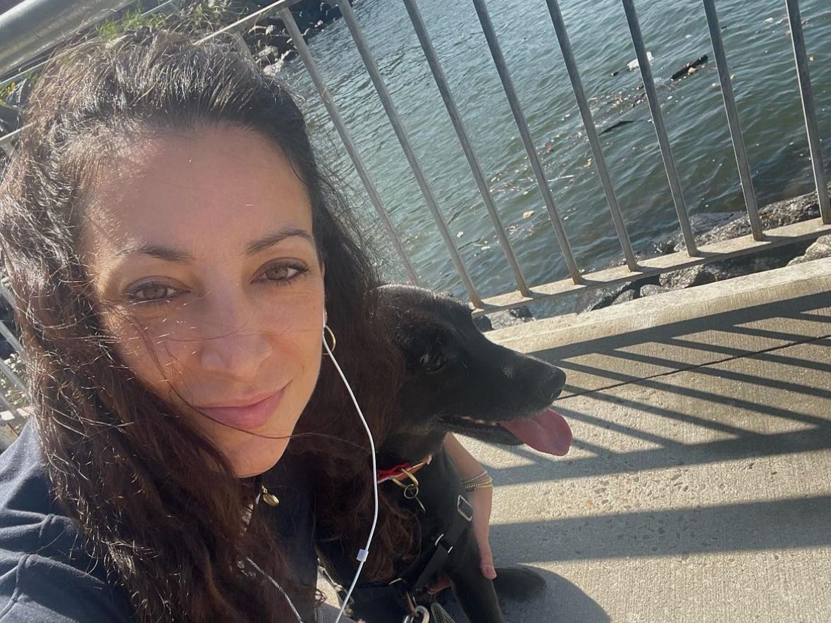Frau mit Hund auf Brücke am Wasser in Brooklyn