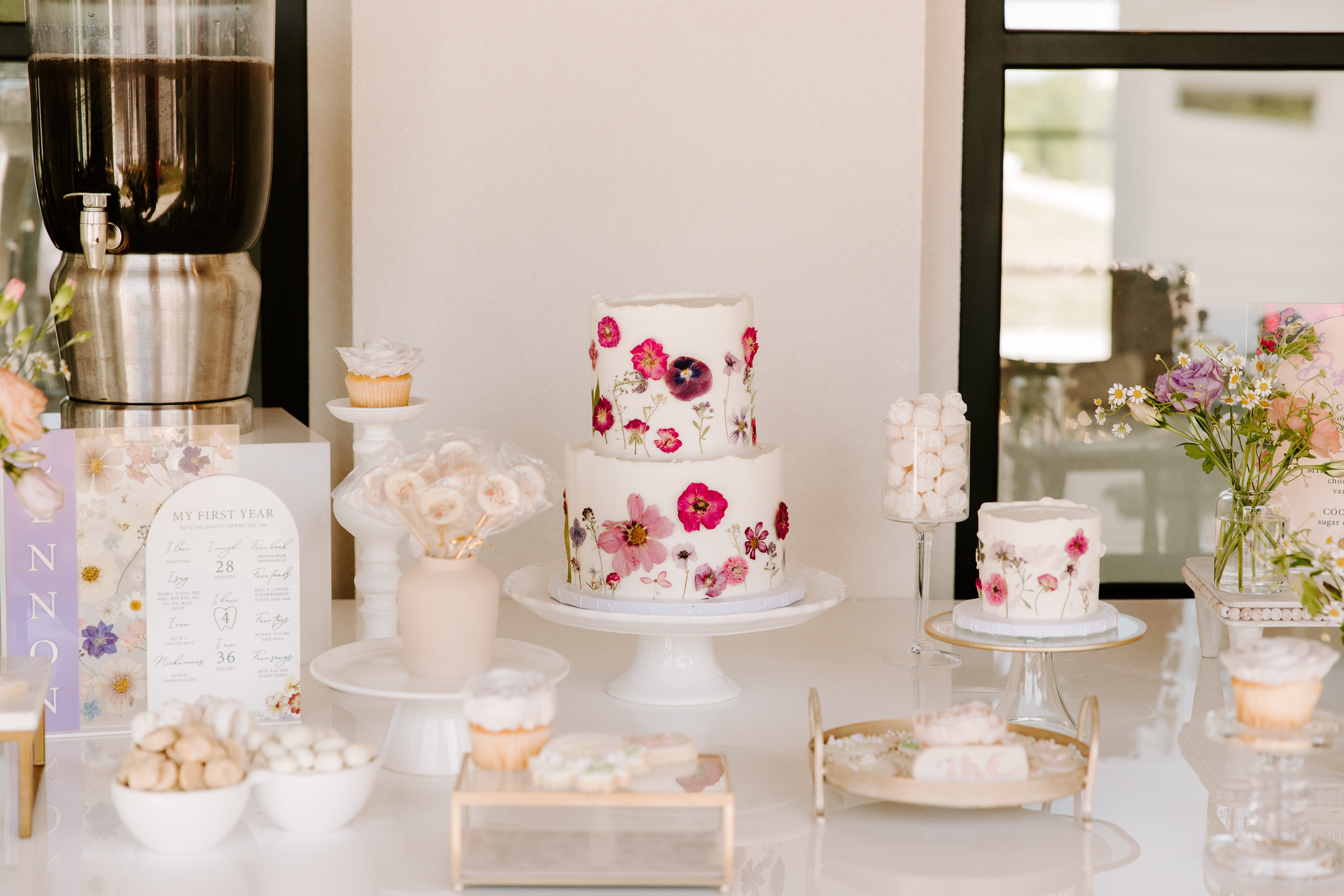 ein Tisch voller weißer Kuchen mit rosa Dekor
