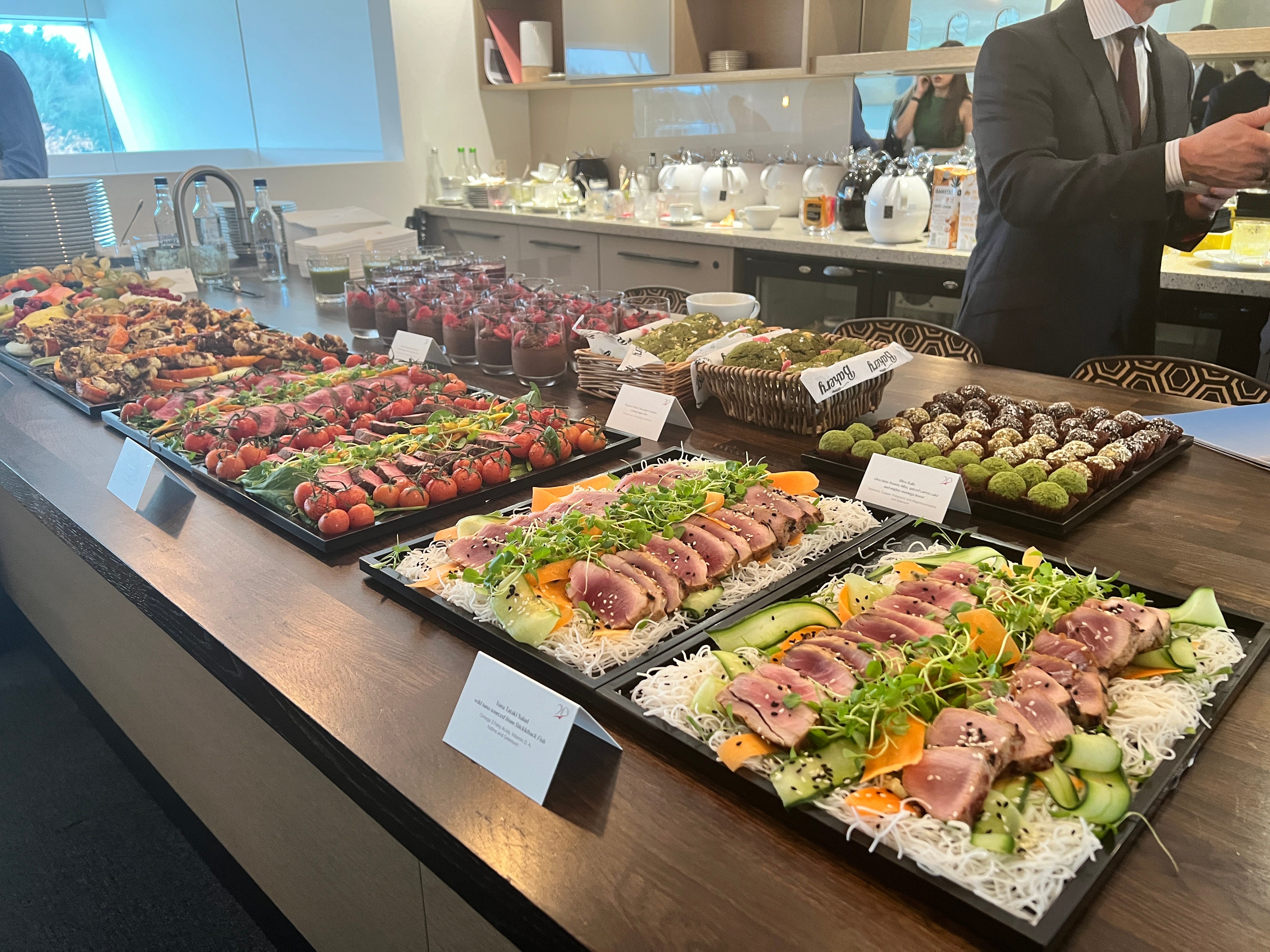 Eine Auswahl an Speisen am Flughafen Farnborough bei einer VistaJet-Veranstaltung umfasst Schokoladenmousse, Thunfisch-Teriyaki und Rinderfiletsalate.