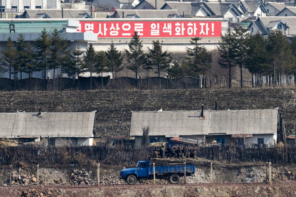 Ein Schild mit der Aufschrift „Lasst uns die Partei und die gesamte Gesellschaft mit den revolutionären Ideen des Genossen Kim Jong Un vereinen!“  in Chunggang.