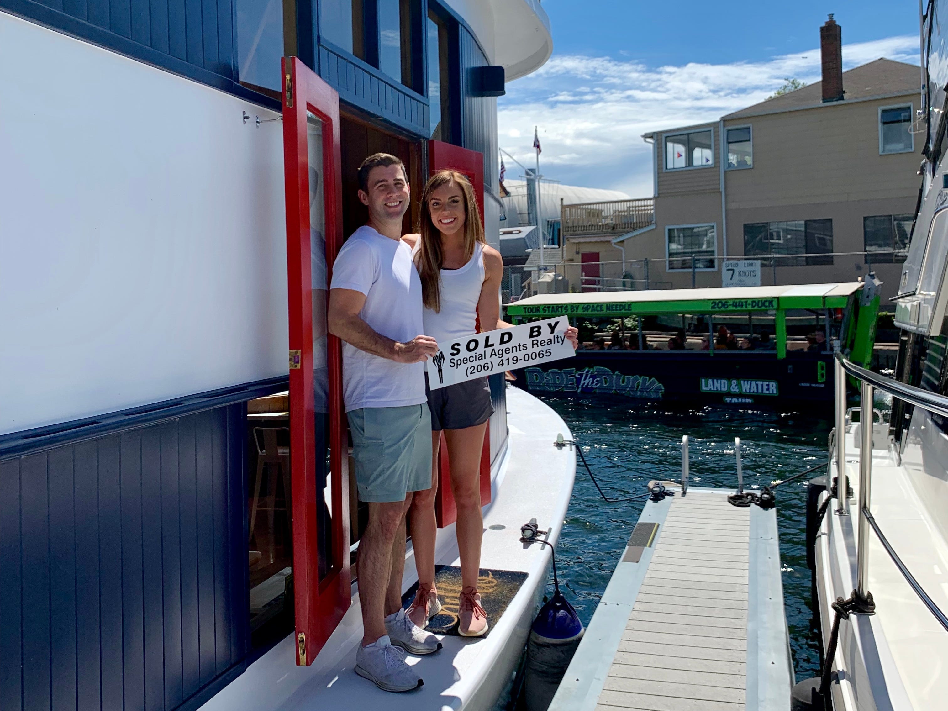Ein Mann und eine Frau posieren neben ihrem Hausboot.