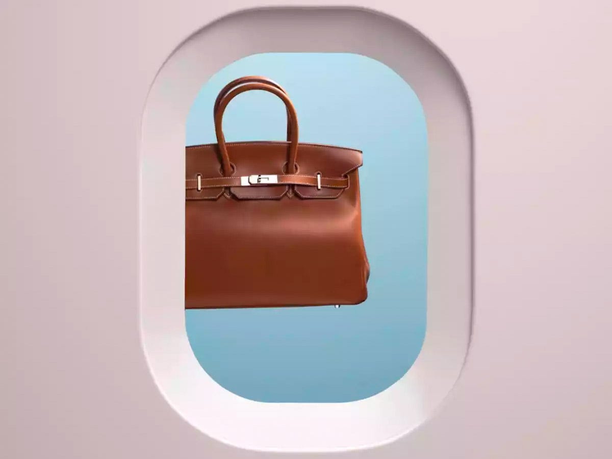 Braune Hermès-Tasche im Flugzeugfenster