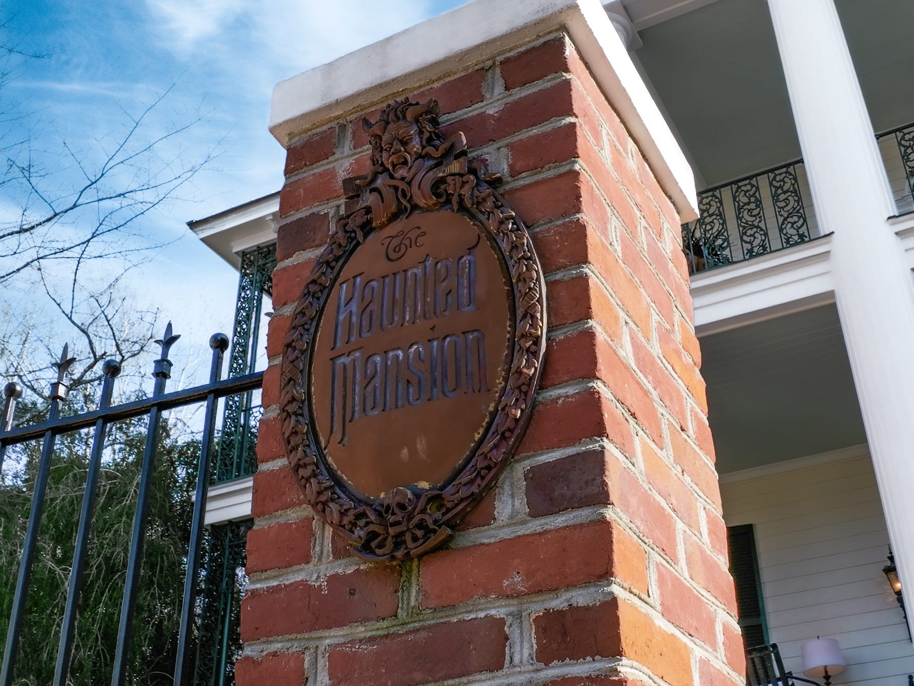 Ein Schild mit der Aufschrift „The Haunted Mansion“ an einem Tor.