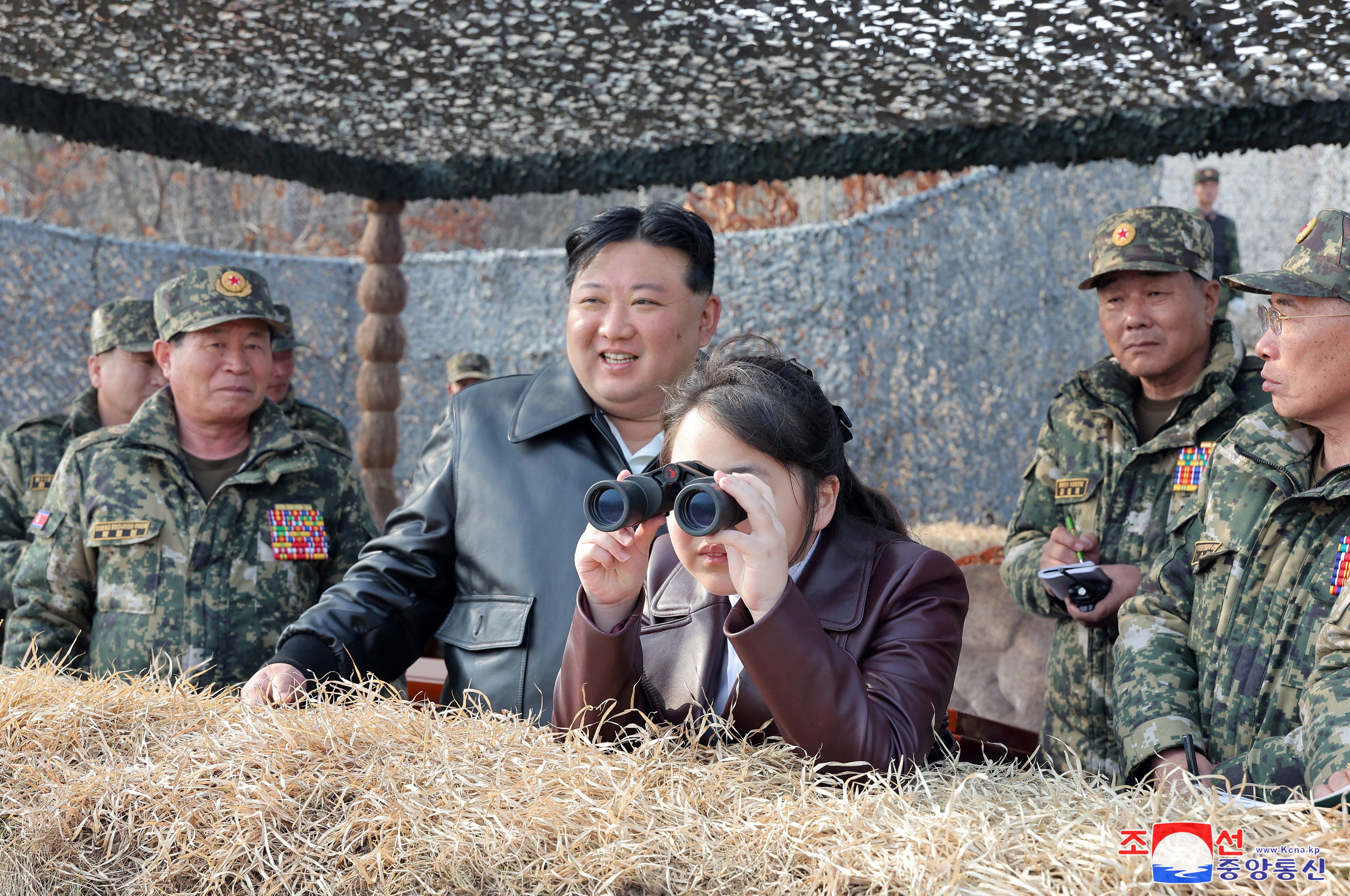 Die Tochter des nordkoreanischen Machthabers Kim Jong Un, Kim Ju Ae, blickt durch ein Fernglas, während sie neben ihrem Vater und nordkoreanischem Militärpersonal steht.