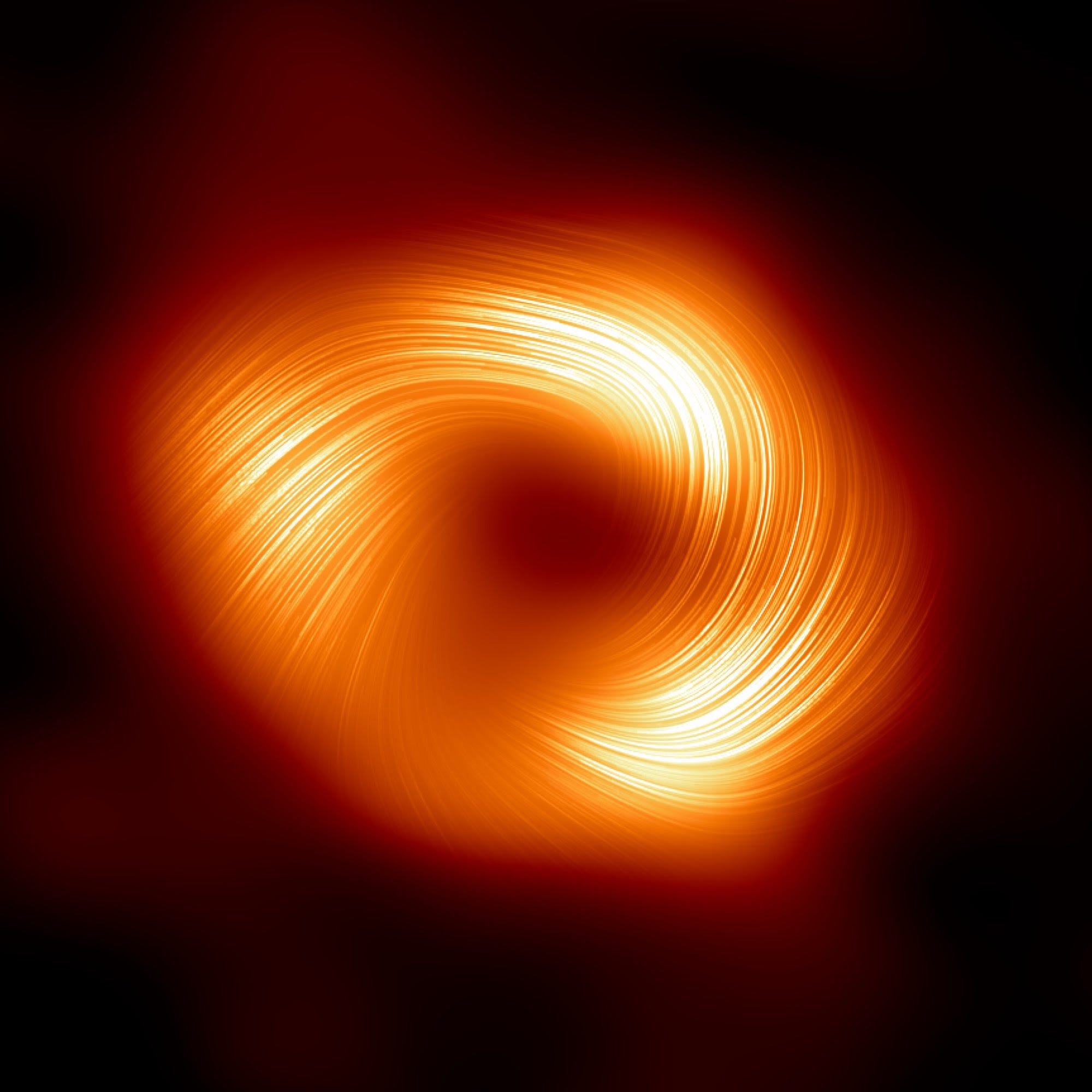 Das Polarisationsbild eines Schwarzen Lochs zeigt einen Kreis aus hellgelbem und diffusem orangefarbenem Licht in der Schwärze des Weltraums mit Linien, die in eine Richtung entlang des Kreises wirbeln, und einem schwarzen Fleck in der Mitte