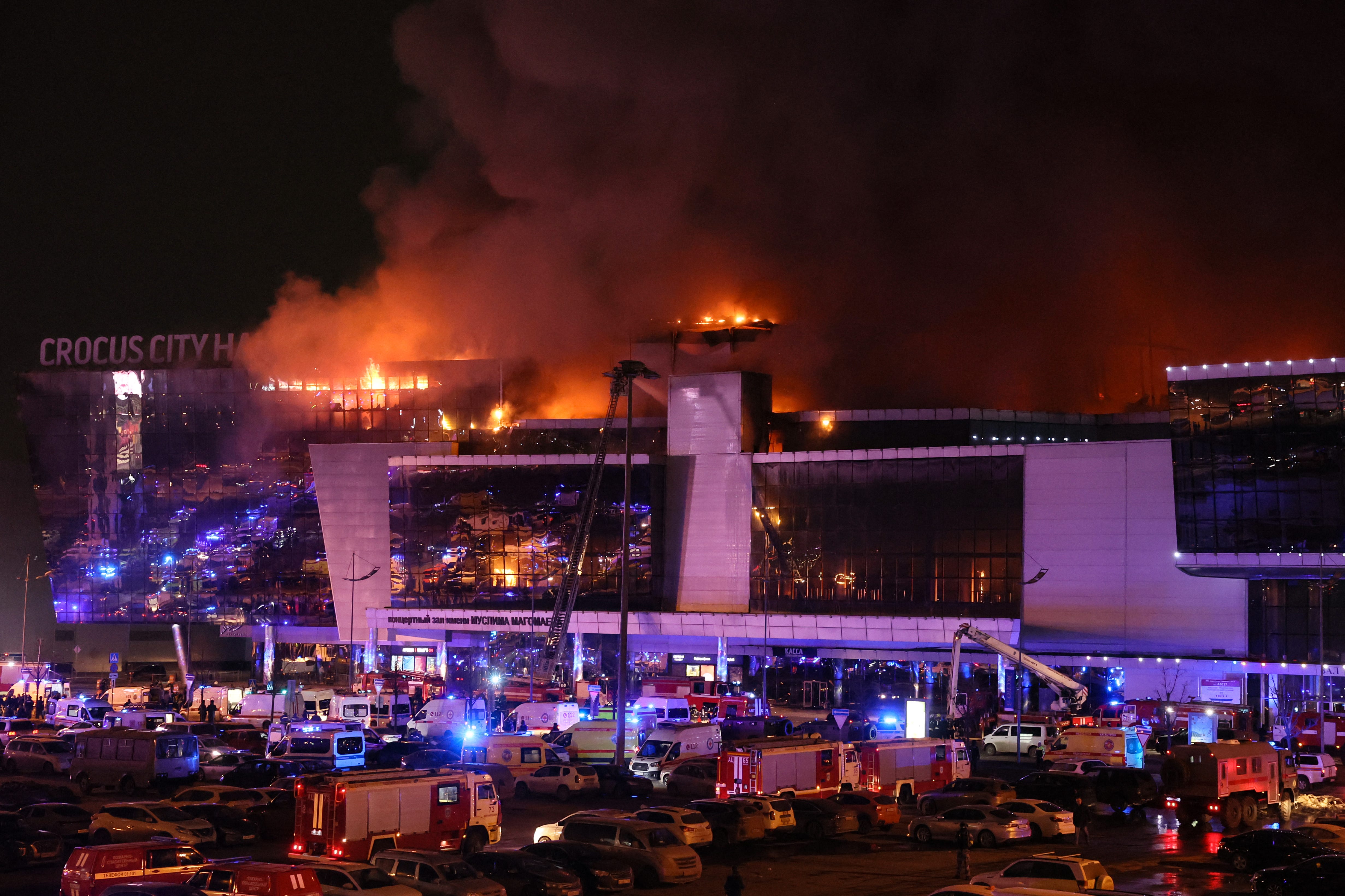 Nach der Schießerei in Krasnogorsk bei Moskau am 22. März 2024 sind Einsatzfahrzeuge vor dem brennenden Konzertsaal des Crocus City Hall zu sehen.