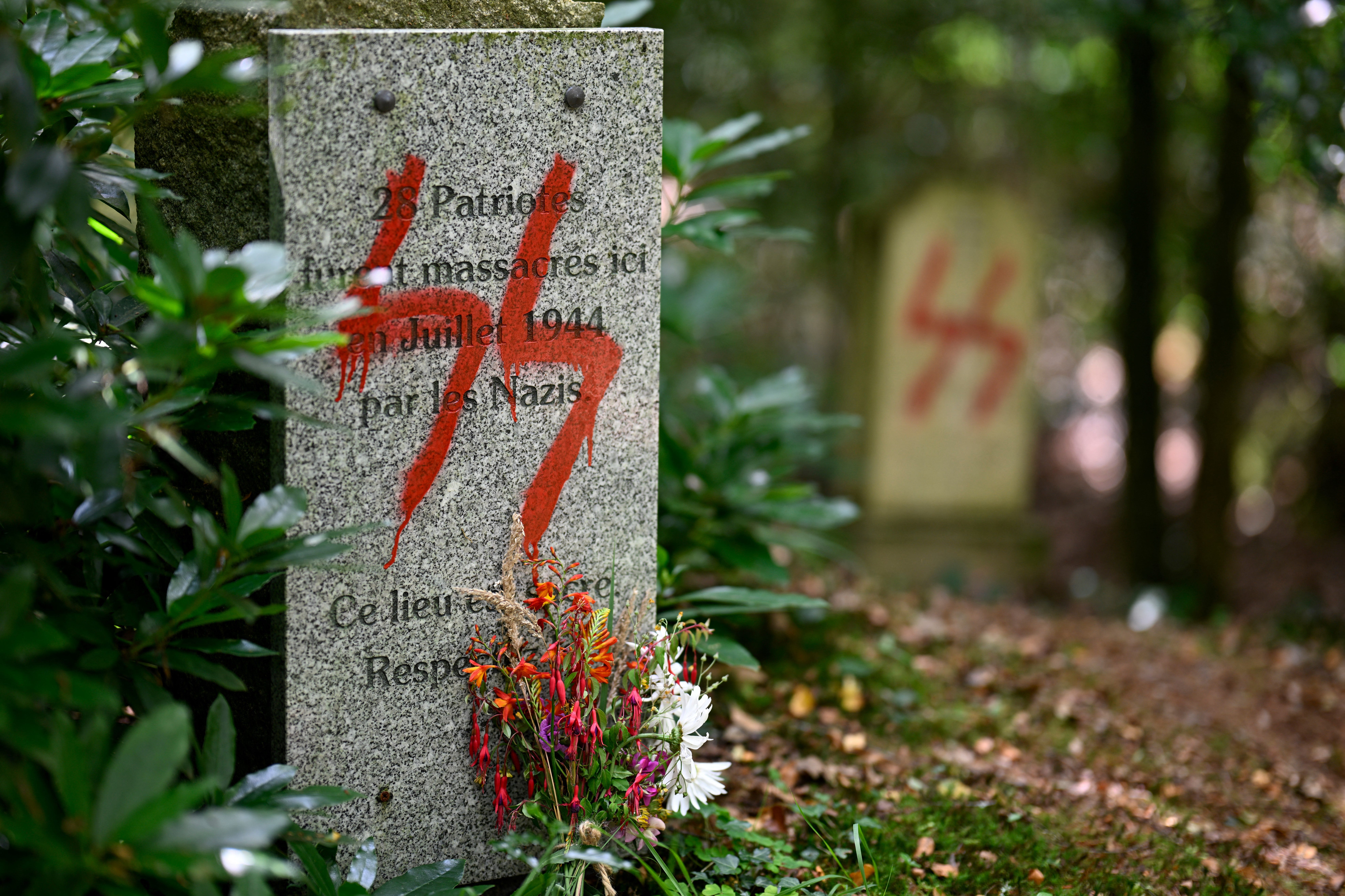 Dieses am 17. Juli 2023 aufgenommene Bild zeigt ein Graffito eines Nazi-SS-Symbols auf einem Denkmal zum Gedenken an 55 Menschen, die an dieser Stelle 1944 während des Zweiten Weltkriegs von den Nazis hingerichtet wurden, in Ploeuc-L'Hermitage, etwa 20 km südlich von Saint -Brieuc, Westfrankreich.