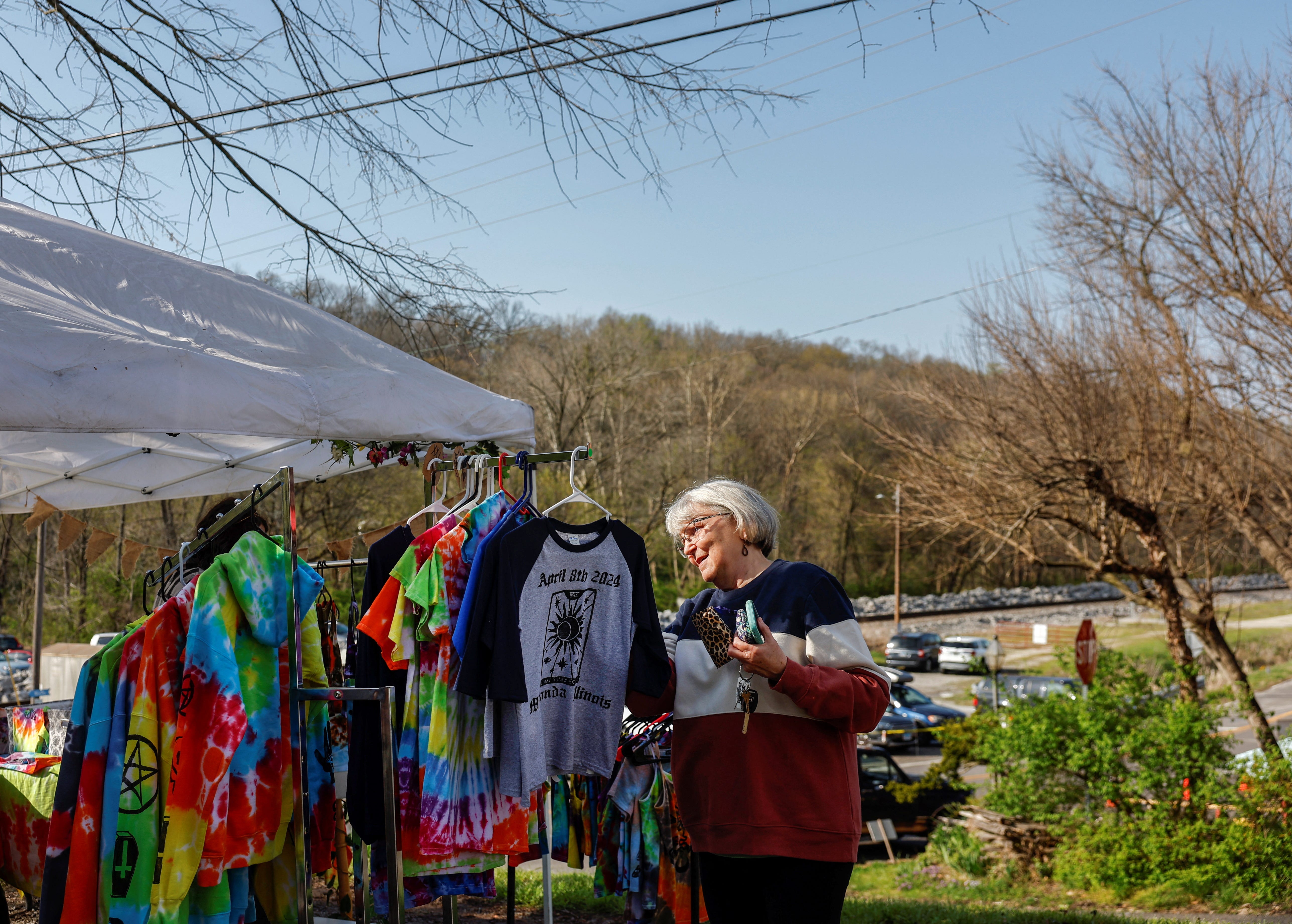 Eine Frau kauft T-Shirts mit Sonnenfinsternis-Motiven im Dorf Makanda mit 600 Einwohnern, das am Schnittpunkt der Sonnenfinsternisse 2017 und 2024 liegt und beide Finsternisse in vollem Umfang erleben, im Süden von Illinois, USA, 7. April 2024.