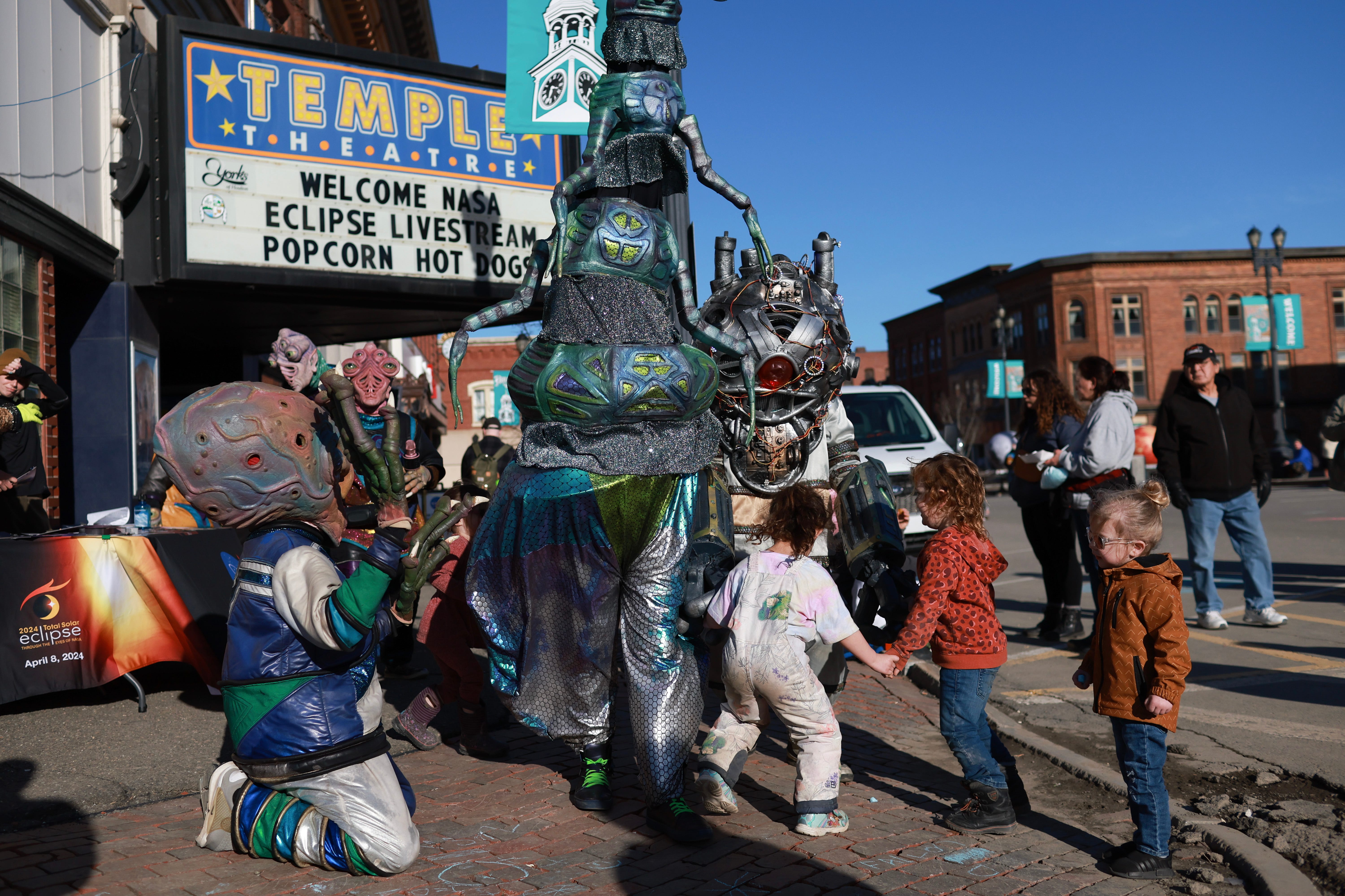 Feierlichkeiten zur Sonnenfinsternis Als außerirdische Kreaturen verkleidete Menschen laufen während eines Sonnenfinsternis-Festivals am 7. April 2024 in Houlton, Maine, über den Hauptplatz