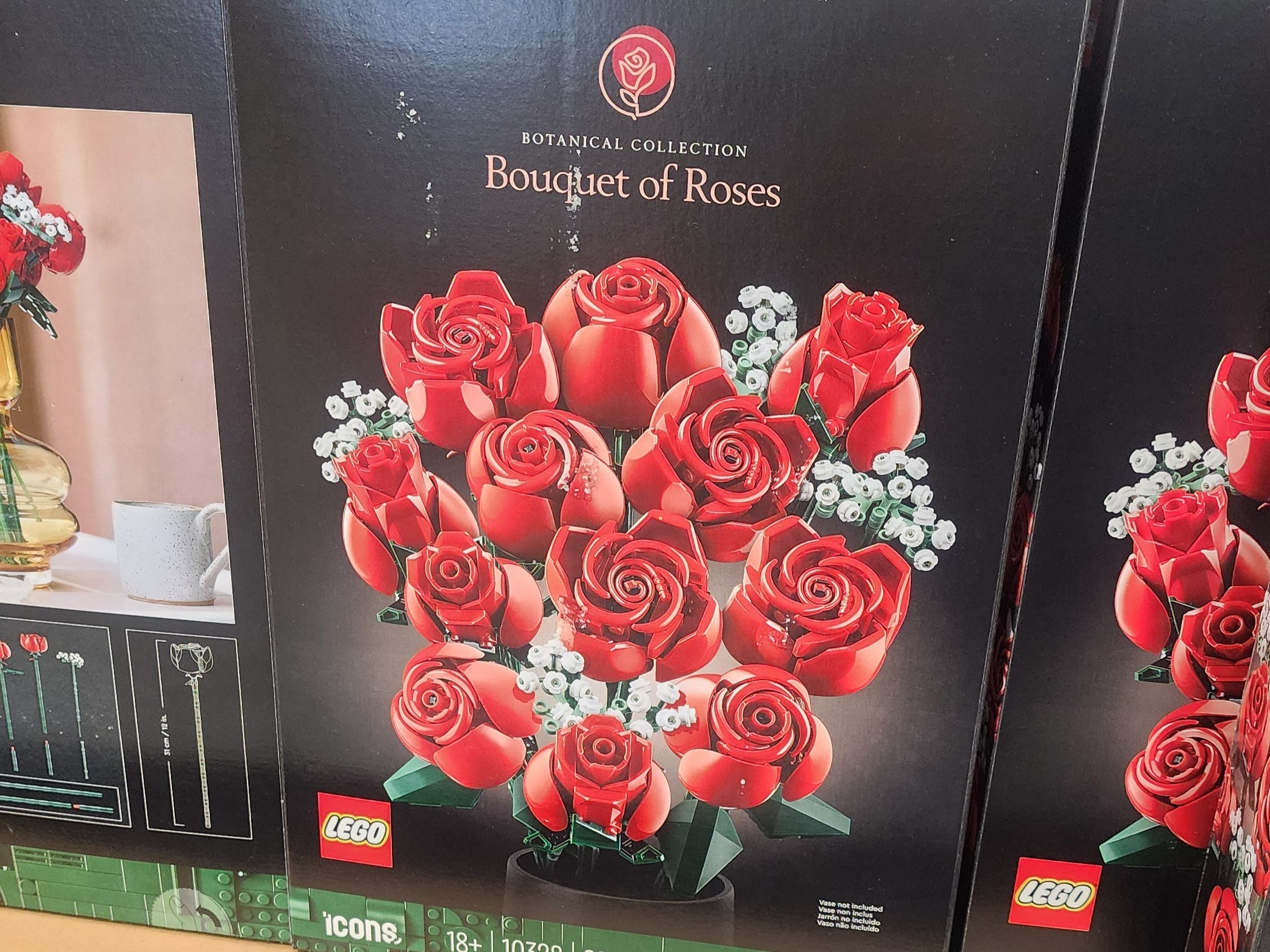 Schwarze Schachteln mit Lego-Rosenstrauß mit Abbildung von Spielzeugblumen auf der Verpackung