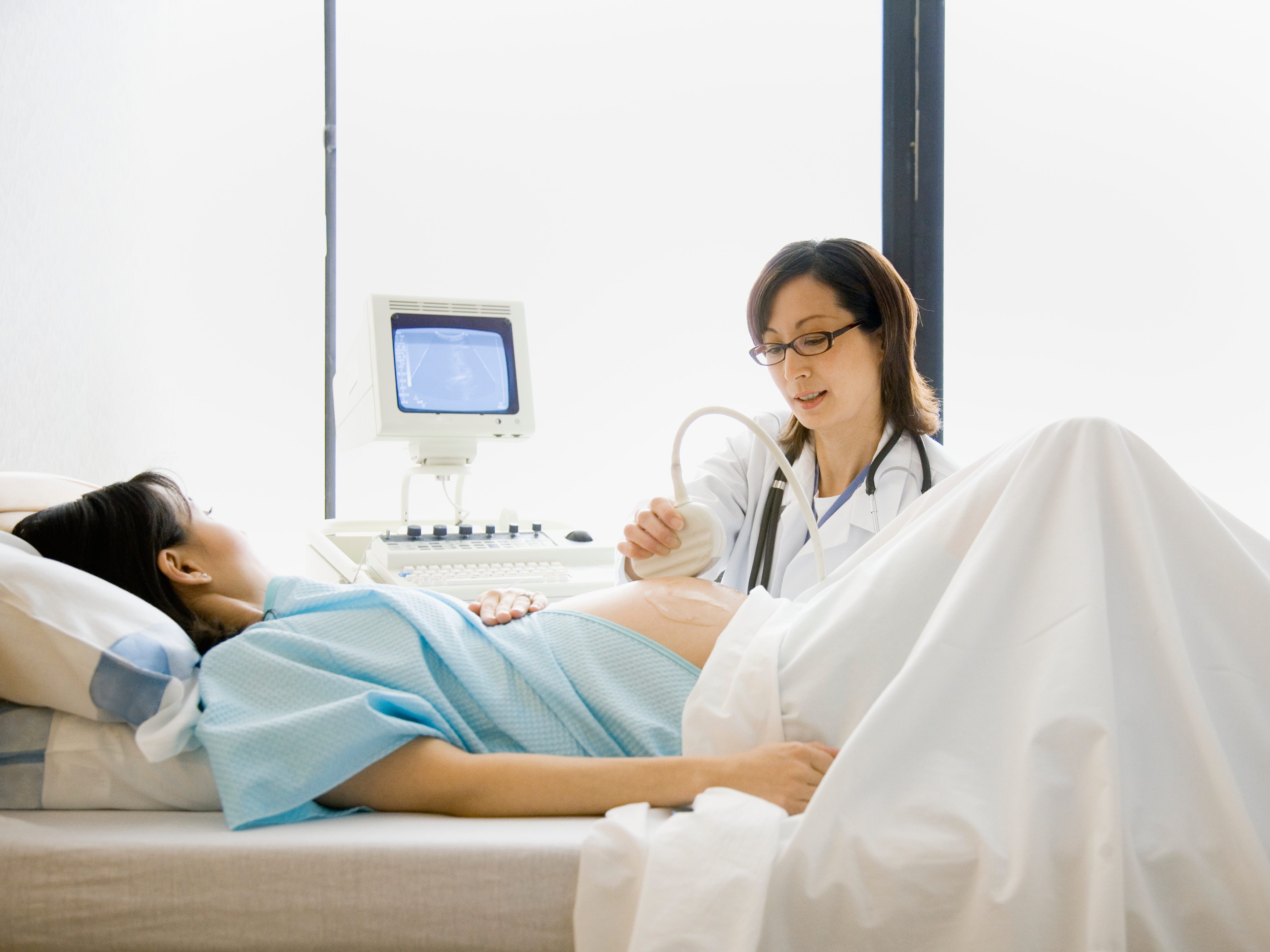Arzt mit einer schwangeren Patientin bei einer Ultraschalluntersuchung