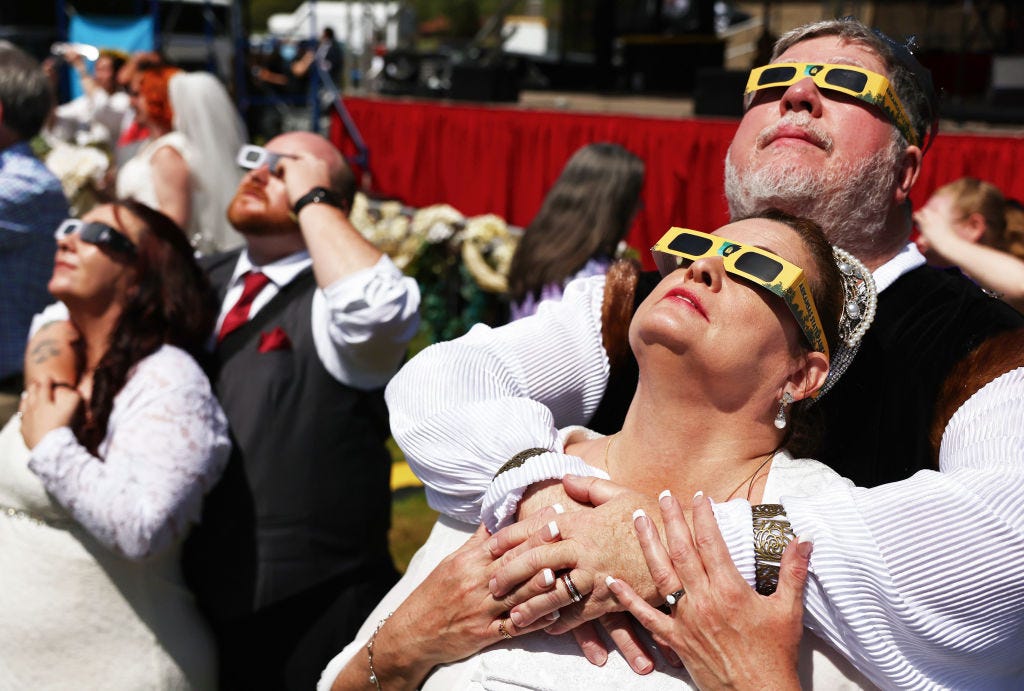 Paare beobachten die Sonnenfinsternis während einer Massenhochzeit beim Total Eclipse of the Heart Festival am 8. April 2024 in Russellville, Arkansas.