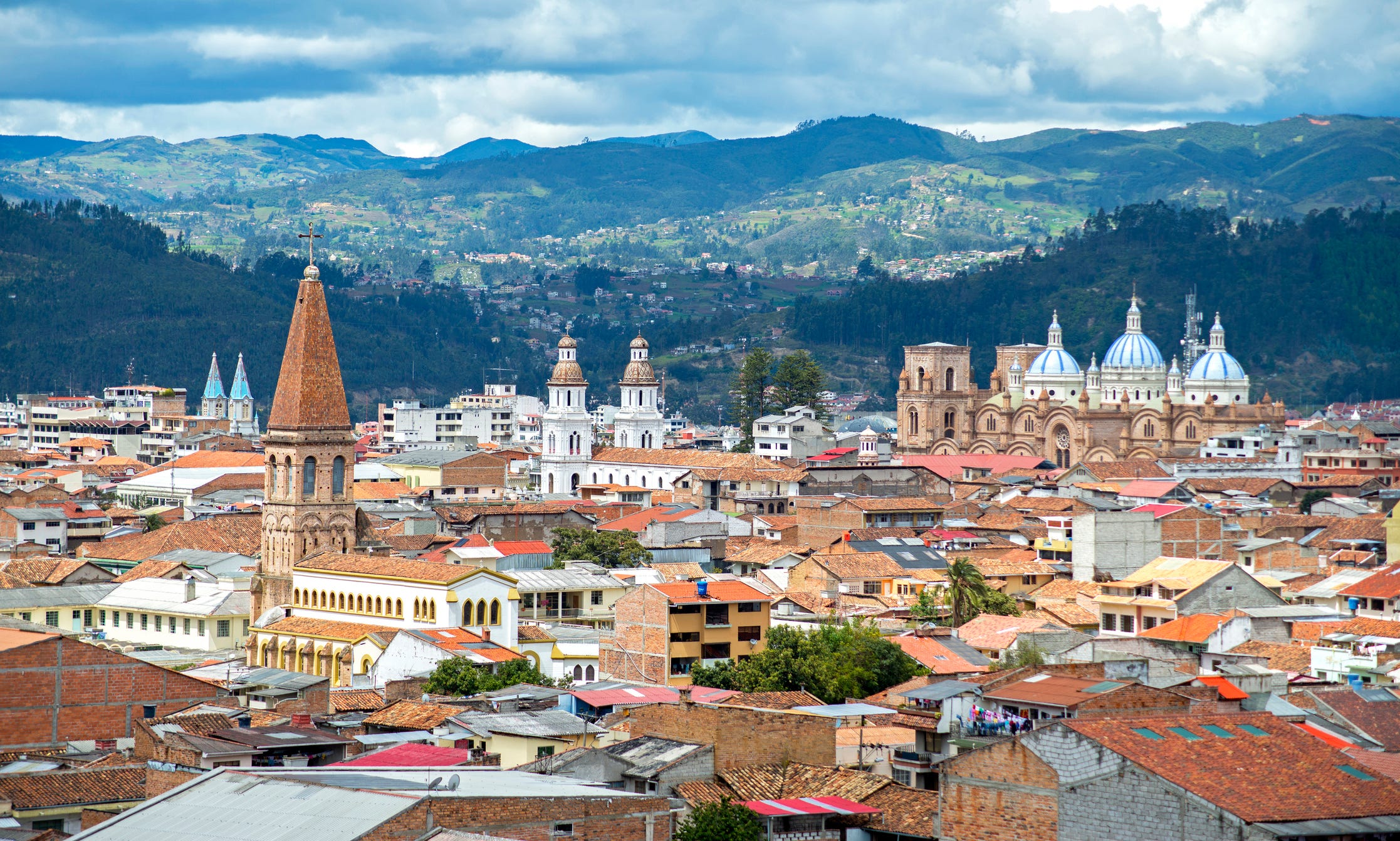 Blick auf die Stadt Cuenca, Ecuador, mit ihren vielen Kirchen und Dächern, an einem bewölkten Tag