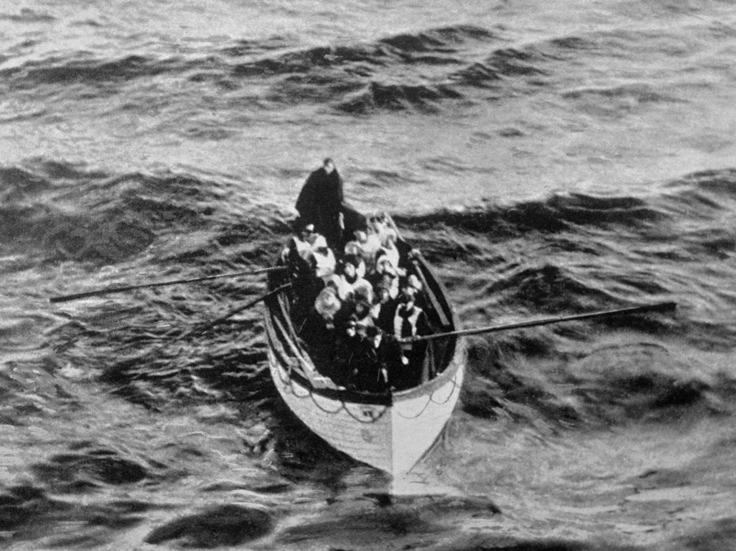 Ein Notkutter-Rettungsboot mit einigen Überlebenden der Titanic, das am Morgen des 15. April, Stunden nach der Katastrophe, in der Nähe des Rettungsschiffs Carpathia trieb.  Die Titanic verfügte nicht über genügend Rettungsboote, um alle ihre Passagiere zu retten, und viele der verfügbaren Boote wurden mit weniger als 65 Passagieren befördert