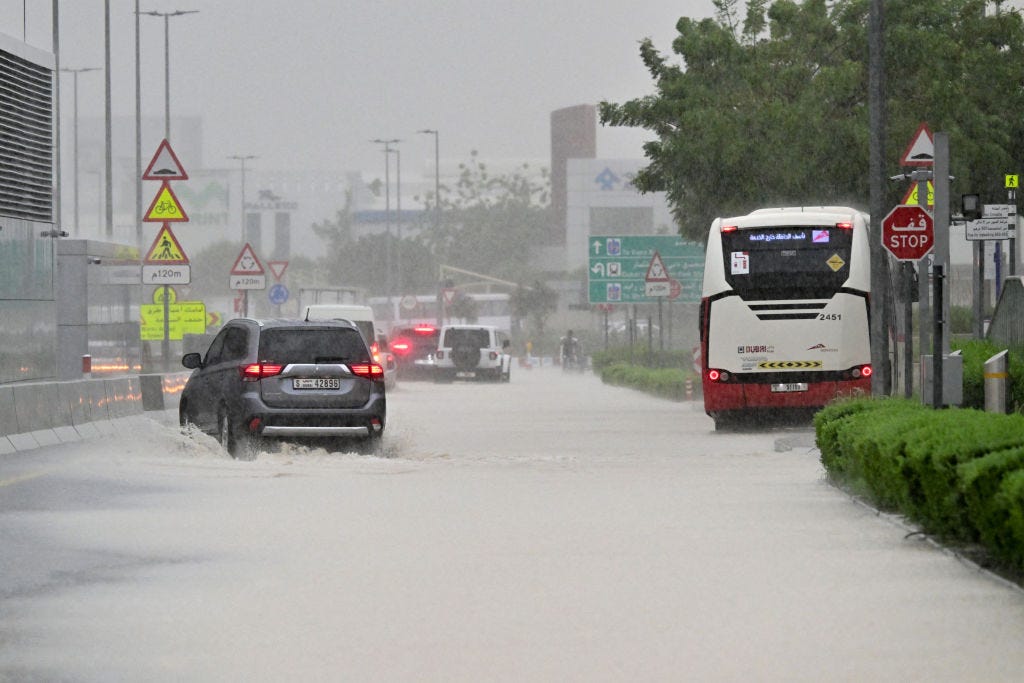 Fahrzeuge fahren am 16. April 2024 bei sintflutartigen Regenfällen im Golfemirat Dubai auf einer überfluteten Straße.