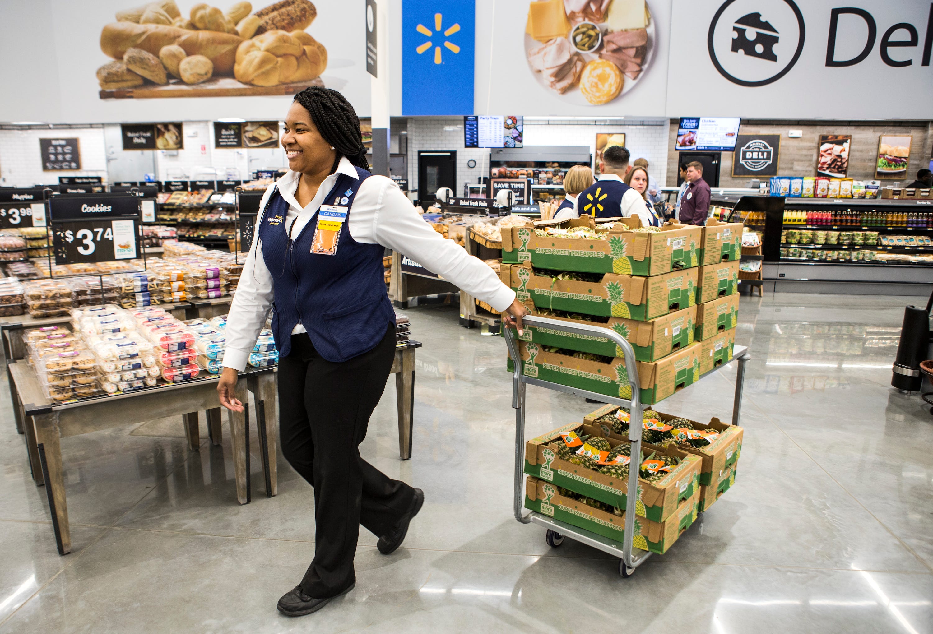 Candais Pipkin, Leiterin der Obst- und Gemüseabteilung, schiebt einen Karren voller Ananas durch einen Walmart-Laden.