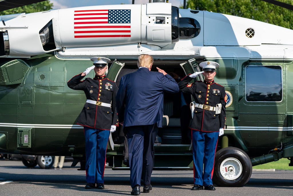 Donald Trump salutiert vor Soldaten, als er an Bord der Marine One geht