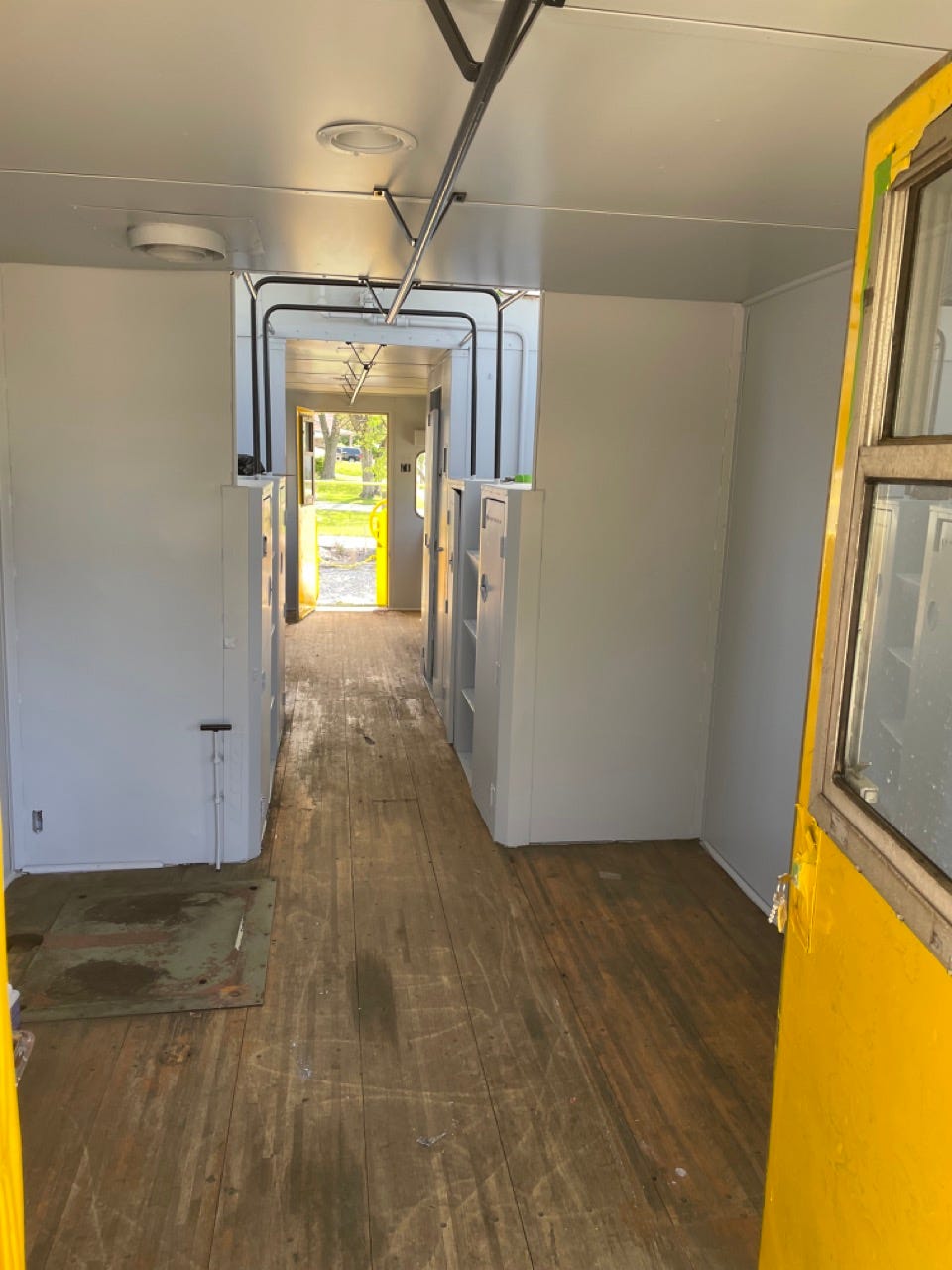 Im Inneren der Chessie-System-Kombüse mit neu gestrichenen weißen Wänden und einer leuchtend gelben Tür. 