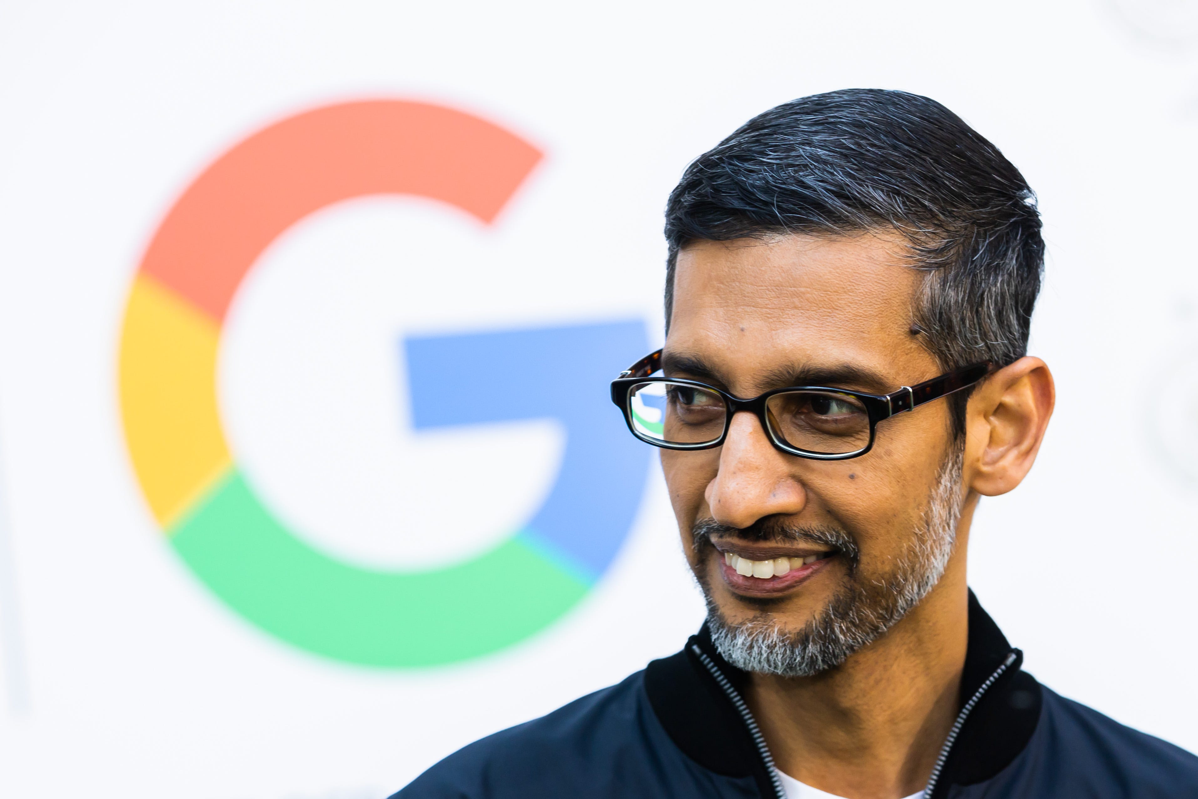 Google-Chef Sundar Pichai steht vor dem Google-Logo.