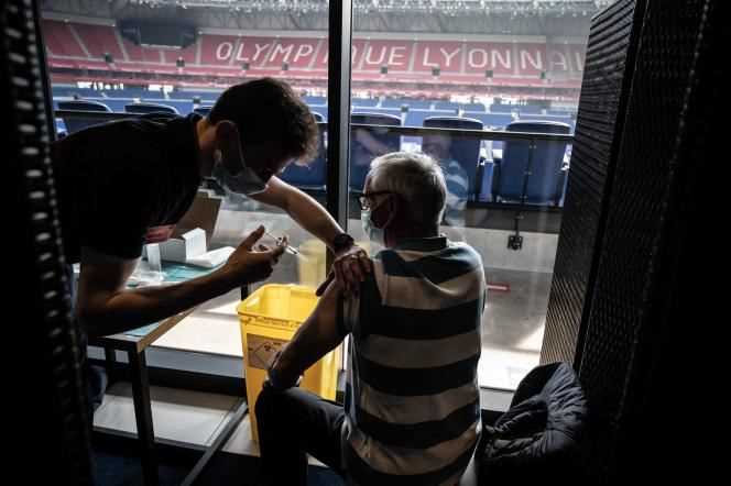 A patient receives an injection of a vaccine against Covid-19 in the stadium of the Olympique Lyonnais.