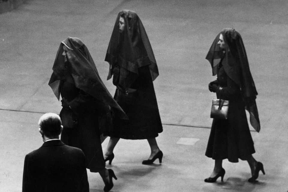 At the funeral of King George VI, his wife and two daughters, Elizabeth (center) and Margaret (right) wear long black veils. 