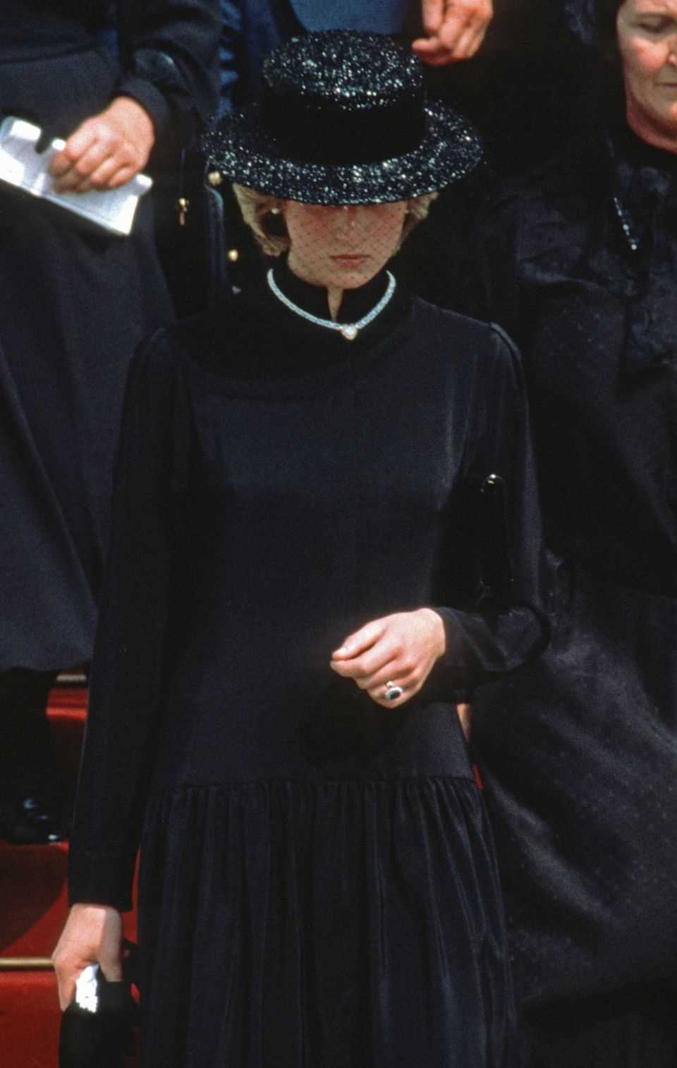 Lady Diana appears alone at the funeral of Grace Kelly in Monaco in 1982.  The engagement ring that Duchess Catherine wears today sparkles on her hand. 