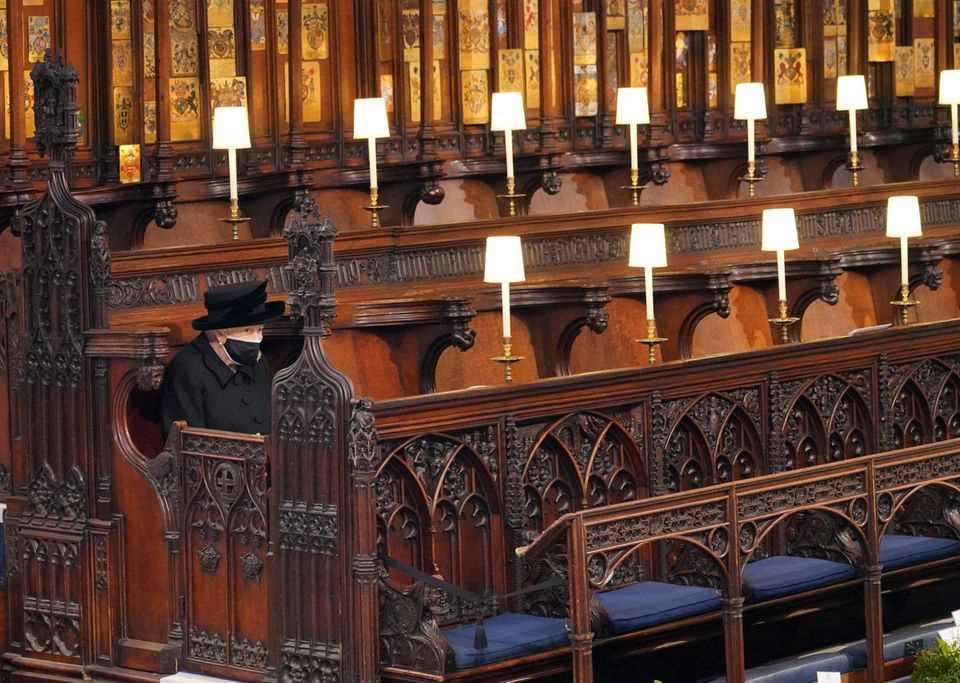 Queen Elizabeth sits alone in St George's Chapel.
