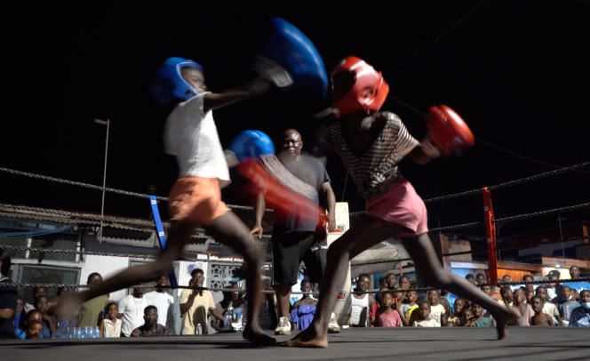 Two female boxer apprentices fight in an open ring in the district of Bokum, in Accra, on March 20, 2021.