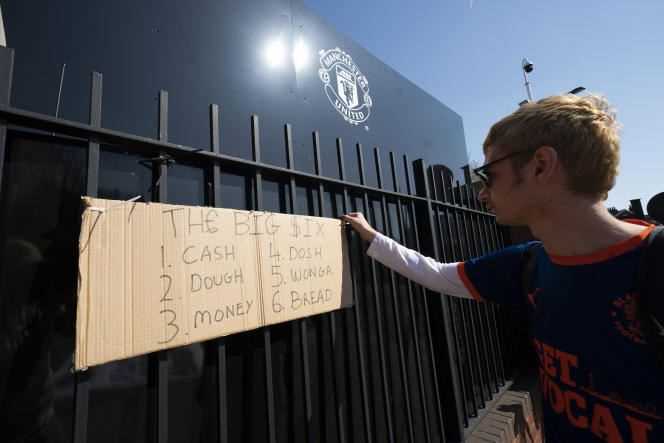 A Manchester United supporter hangs a poster hostile to the Superleague project outside Old Trafford Stadium on April 19.