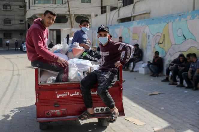 Palestinian youths take food they received from a United Nations-run aid distribution center in Gaza on April 7.