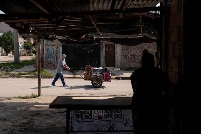A man whose job is to collect objects and other waste walks past the soup kitchen in the Libertador district on April 16.