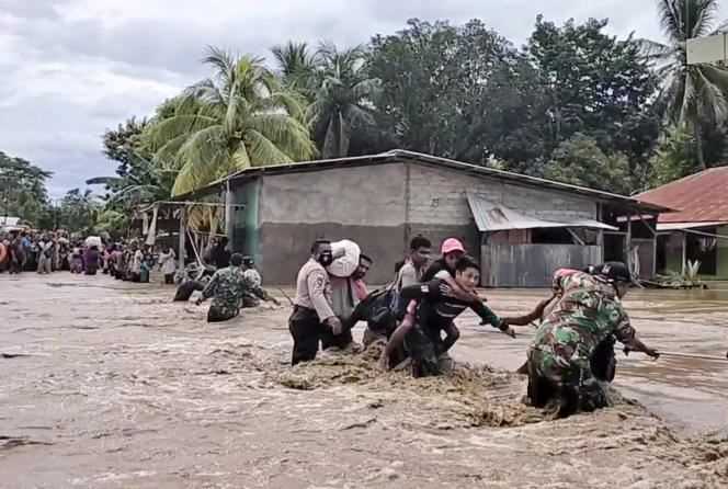 In this video, soldiers and police help residents cross a flooded road in Malaka Tengah, Indonesia, April 5.